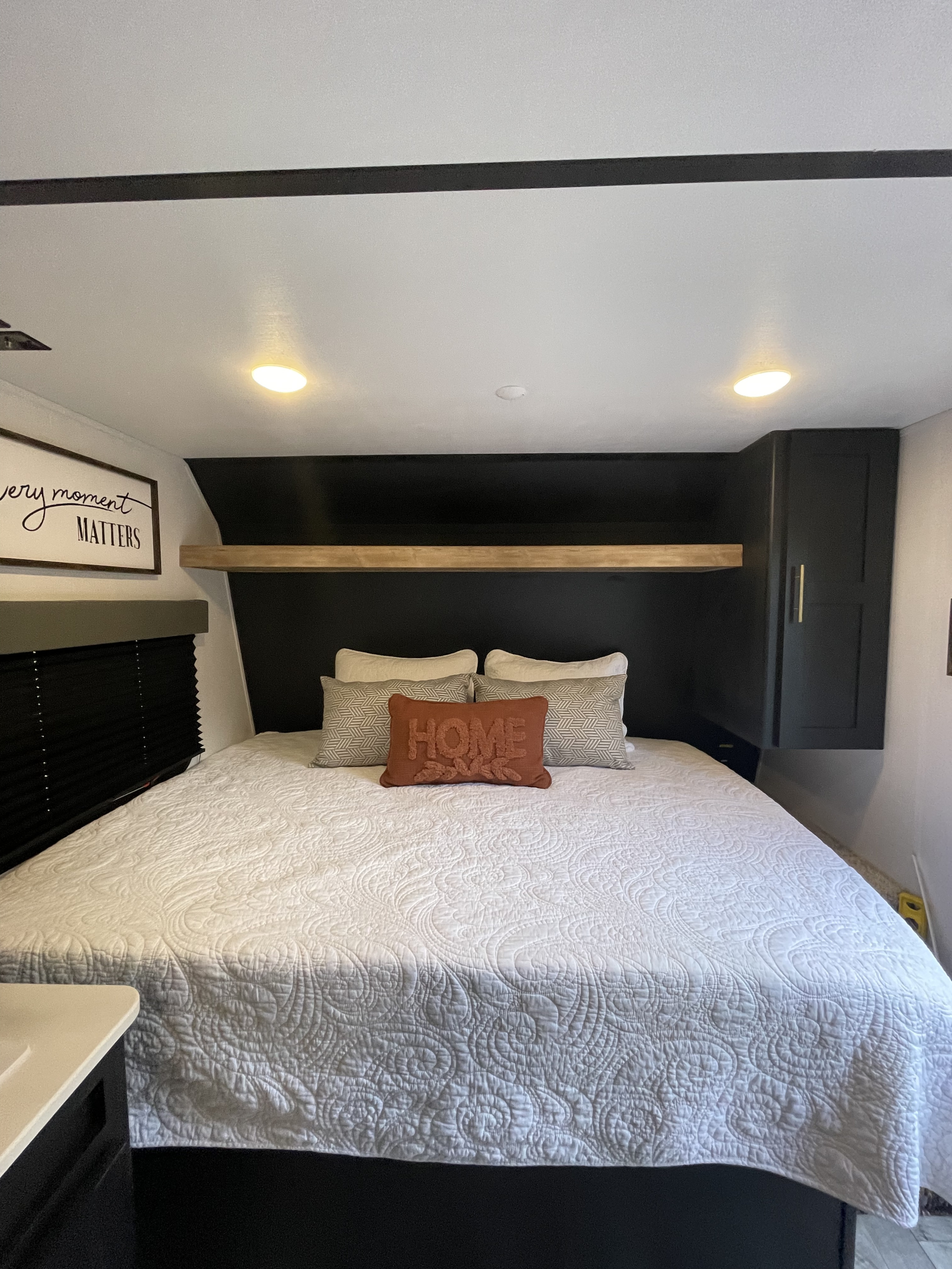 Step inside this cozy RV rental's bedroom, complete with a comfy bed, wall art, and practical storage.. Keystone Springdale 2022