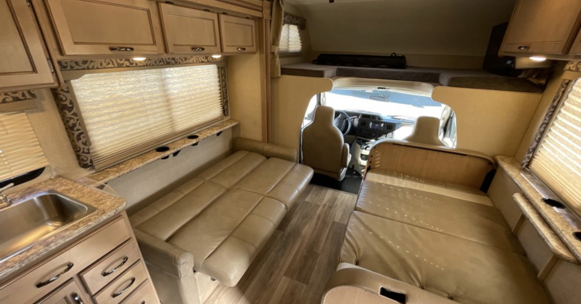 View inside an rv rental, featuring a kitchenette, two convertible sleeping areas, and an overhead bunk.. Thor Motor Coach Four Winds 2020