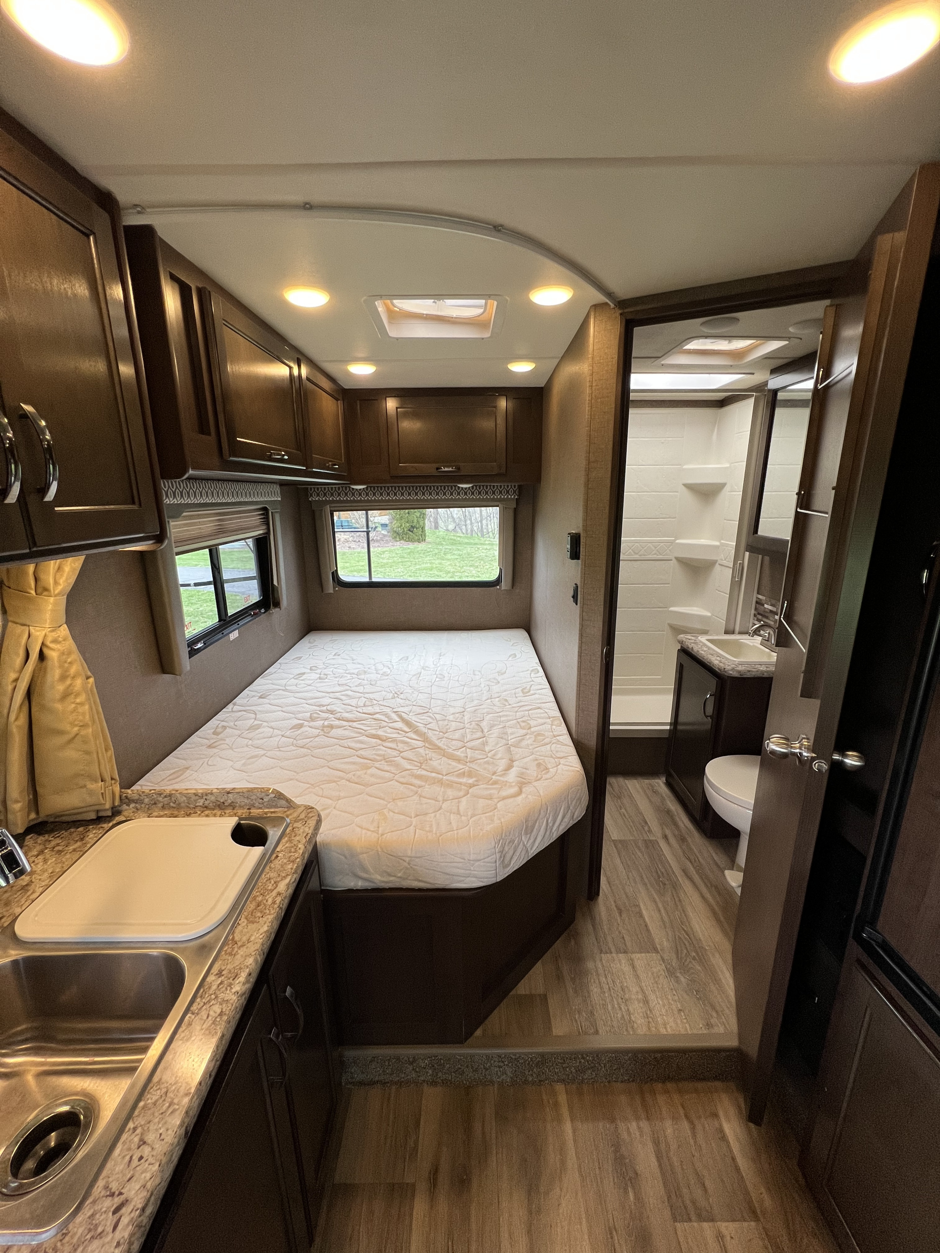 Cozy rv rental interior: bedroom, kitchenette, and bathroom with shower. Perfect for your next adventure!. Thor Freedom Elite 2017