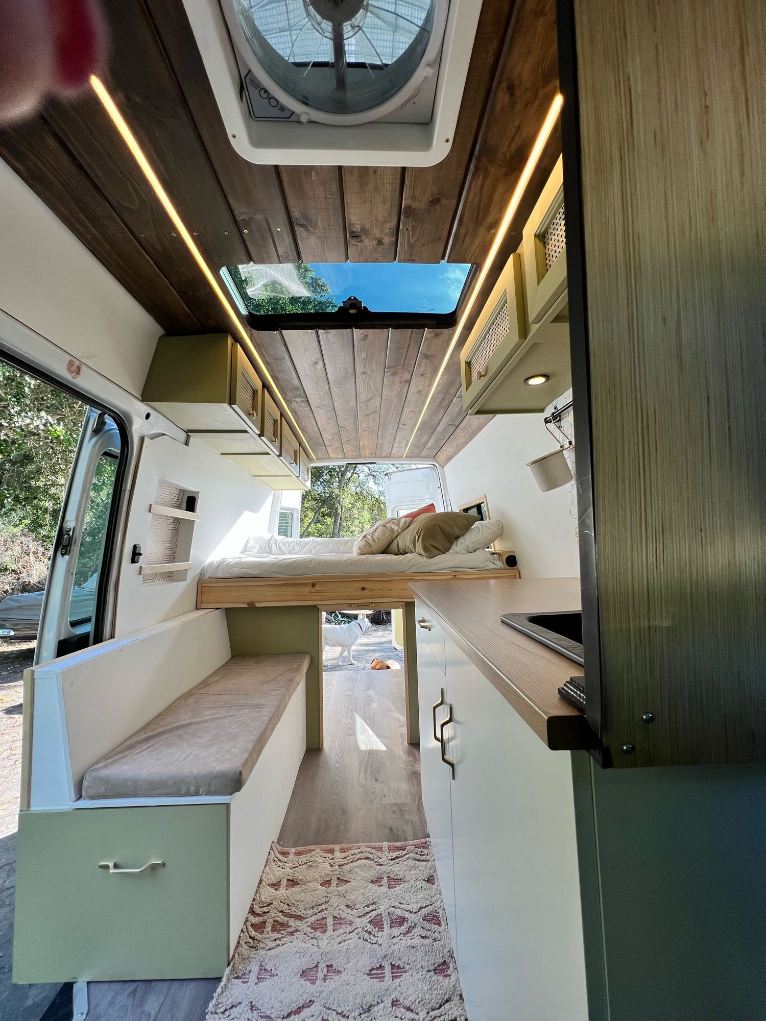 Step inside this RV rental! Enjoy a custom camper van interior with elevated bed, full kitchen, bright wood ceiling lights, and skylight.. Mercedes-Benz Sprinter 2006