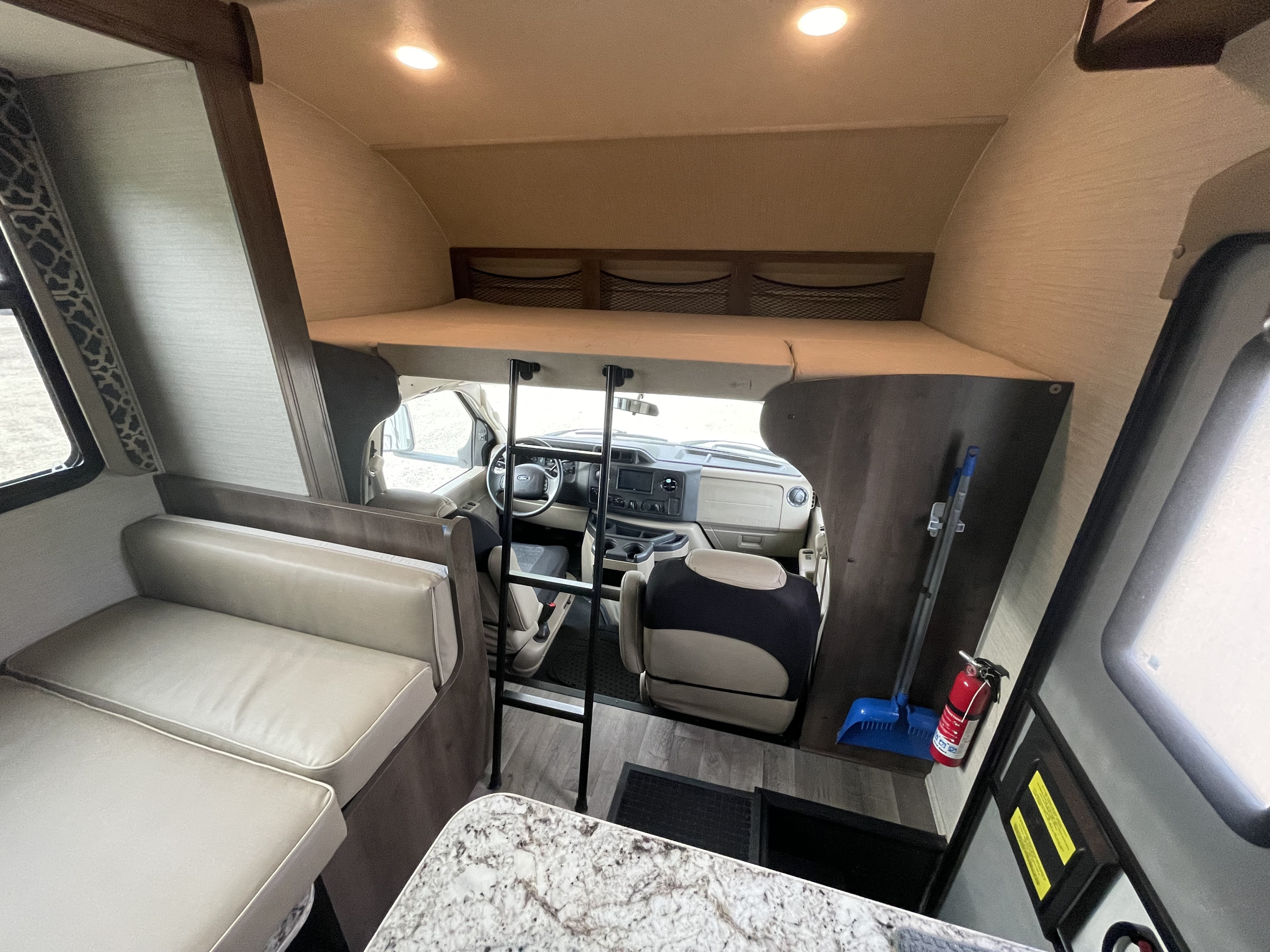 RV rental interior showcasing the living area, overhead bunk with ladder, and driver's cab. Ready for camping trips.. Jayco Redhawk 2018