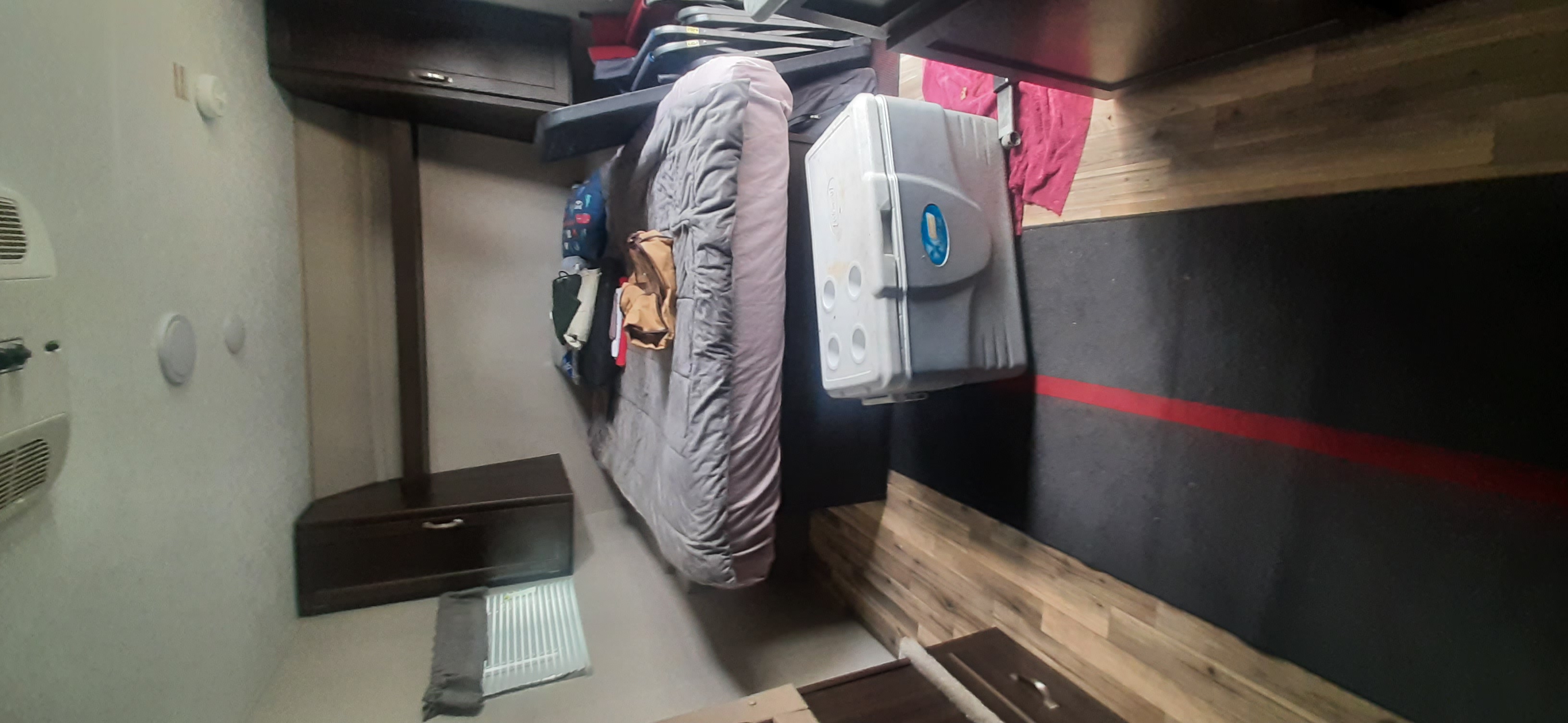 RV rental interior: cozy bed, portable cooler, and storage optimize your comfort and space.. Keystone RV Springdale 2019
