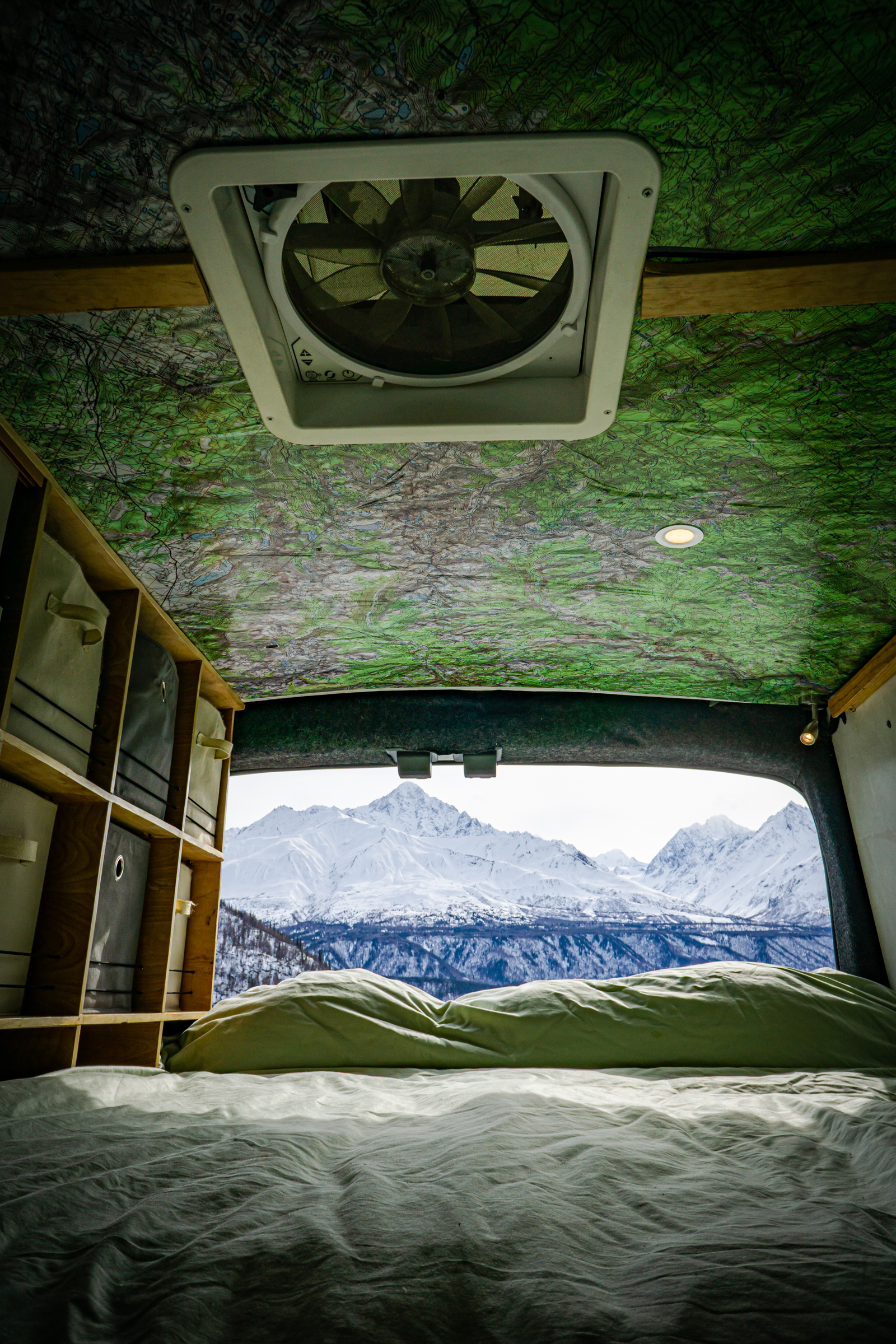 Wake up to stunning views! This rv rental offers a cozy bed, map ceiling, storage, & a vent with snowy mountain vistas.. Ford Transit Custom 2015