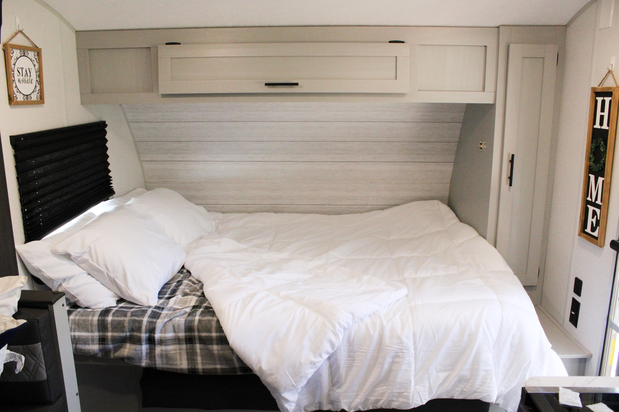 Relax in this clean and cozy RV rental bedroom. Features a comfortable bed with white bedding, storage, and decor.. Forest River Salem FSX 2021