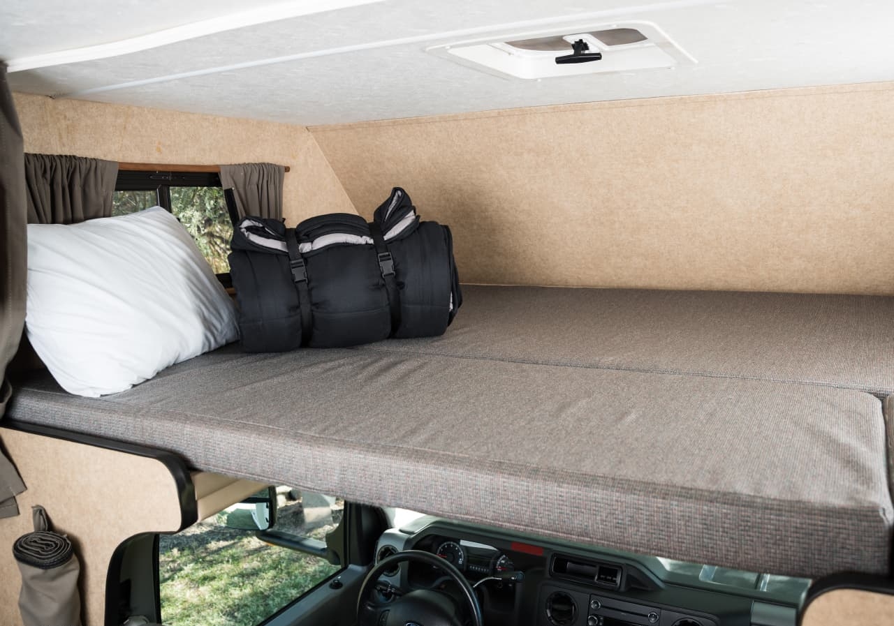 Inside this RV rental, find a comfortable overcab bunk bed with a pillow and sleeping bags, ready for your adventure.. Thor Majestic 2015