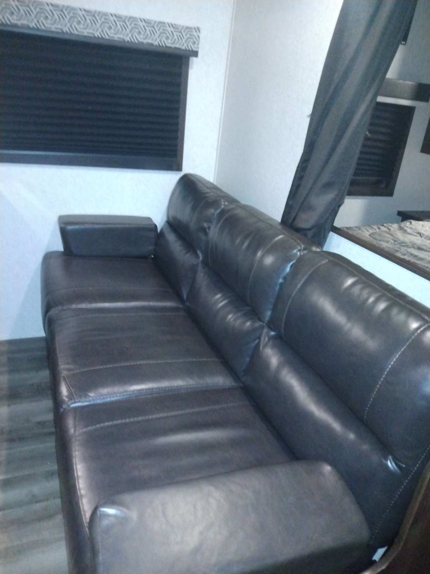 RV rental interior: A dark leather sofa, modern window blinds, and comfy bed area create a relaxing space.. Jayco FLIGHT SLX 2020