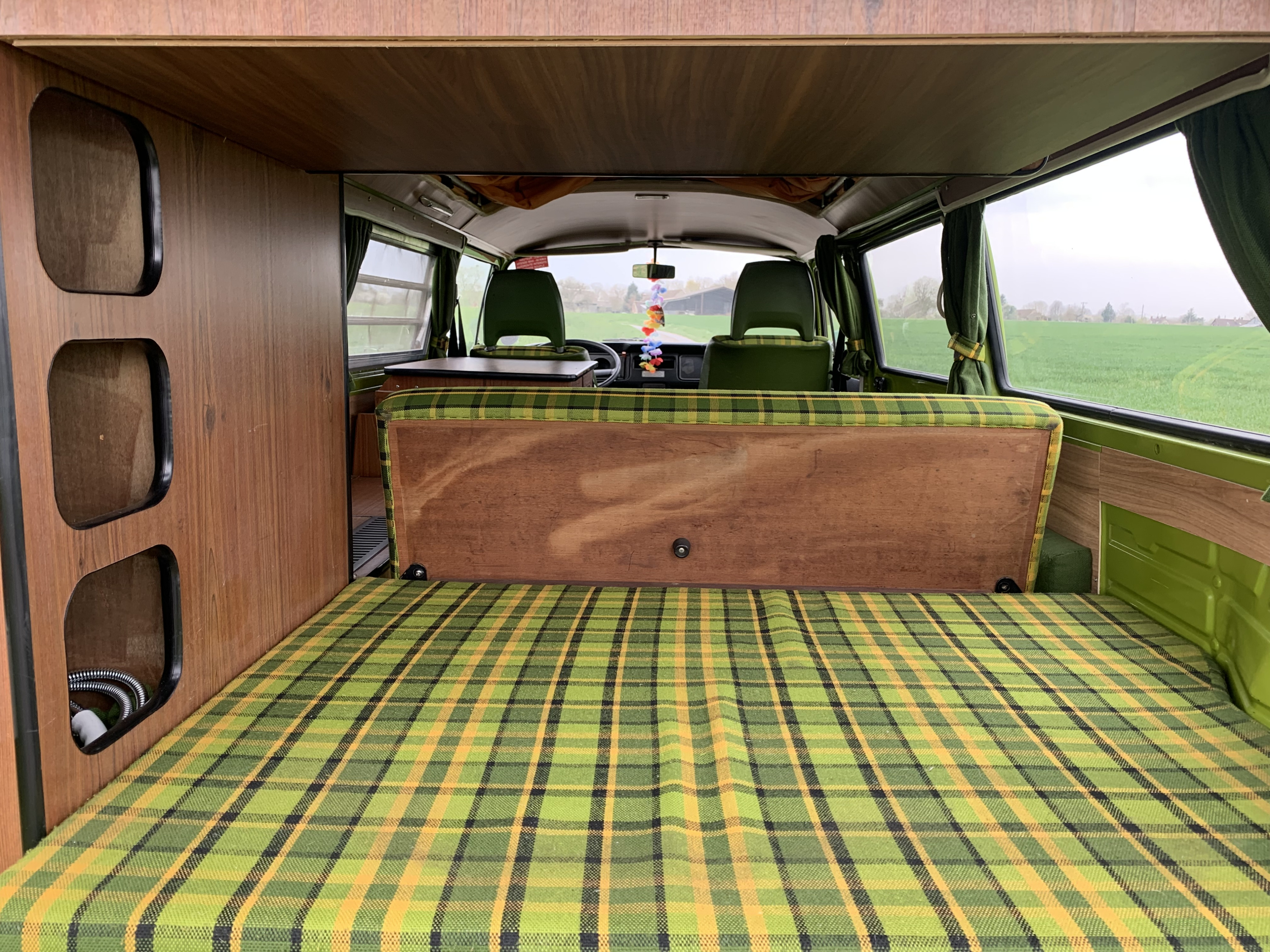 Vintage rv rental: Step inside this camper van with plaid bed, wood panels, and front cabin view.. Volkswagen westfalia 1978