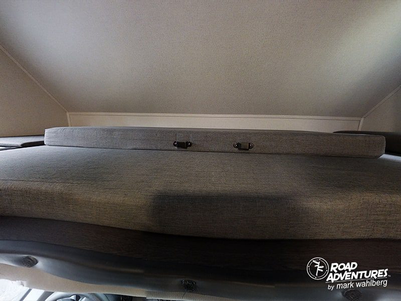 RV rental's comfy grey bed cushions & overhead bunk. Perfect sleeping space for your next road trip.. Forest River Sunseeker 2023