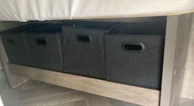 RV rental organization: Four black fabric storage bins neatly tucked under a bed provide smart space solutions for your travel essentials.. Forest River Salem 2021