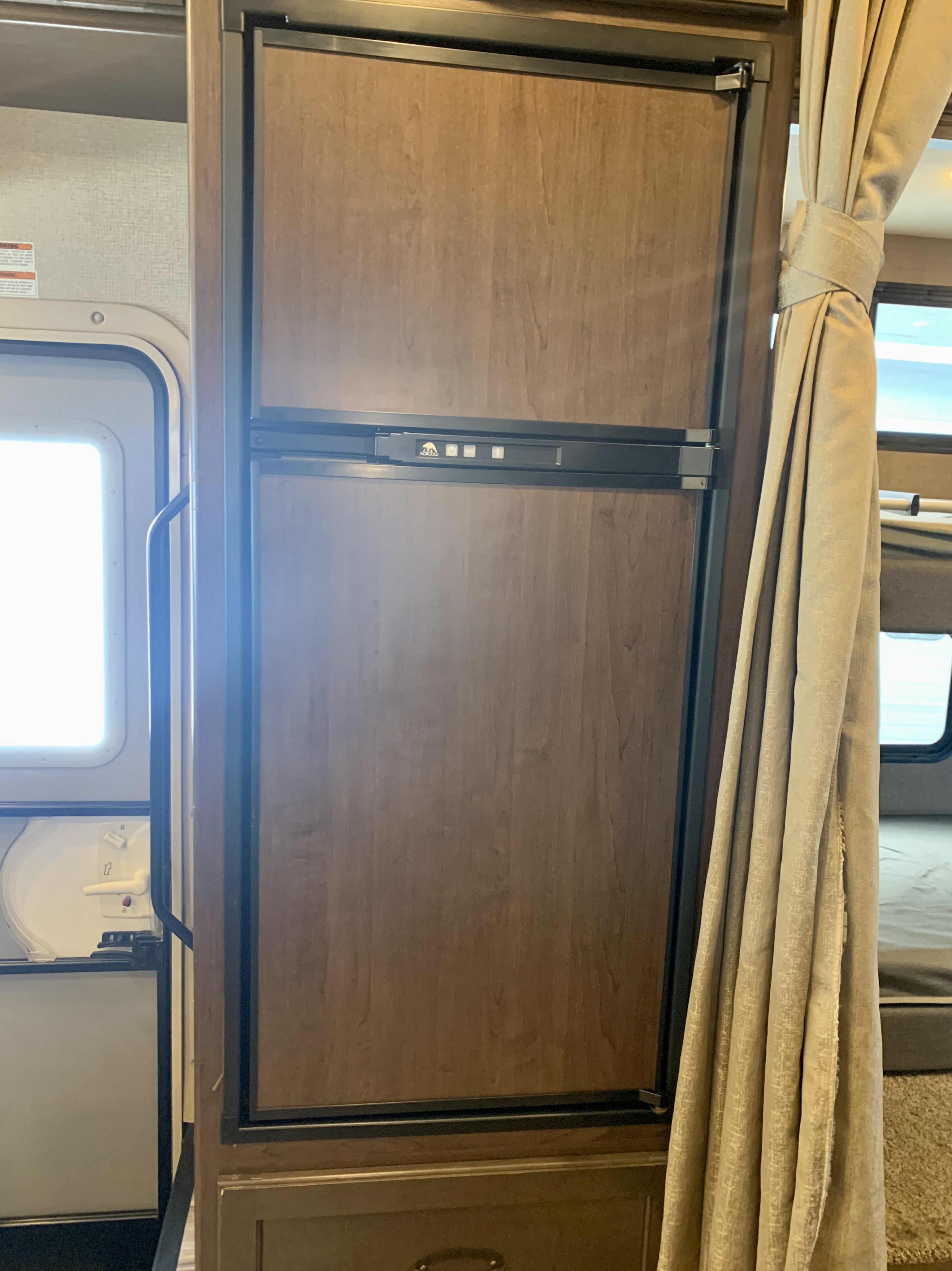 This RV rental features a built-in wood-paneled refrigerator, a key amenity for your travels.. Thor Motor Coach Four Winds 2018