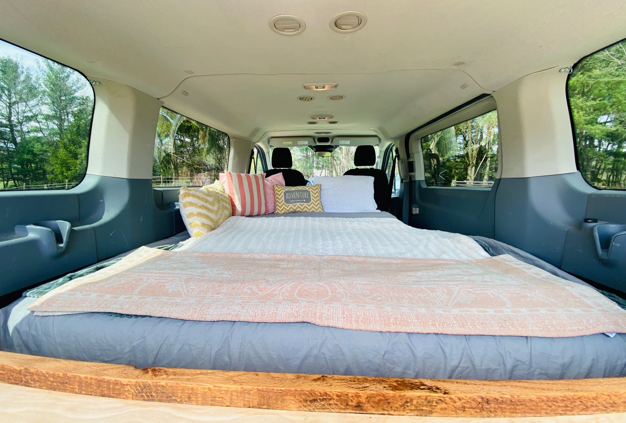Step inside this RV rental, featuring a cozy bed setup. Ideal for adventurous van life and camping trips.. Ford Transit 2015