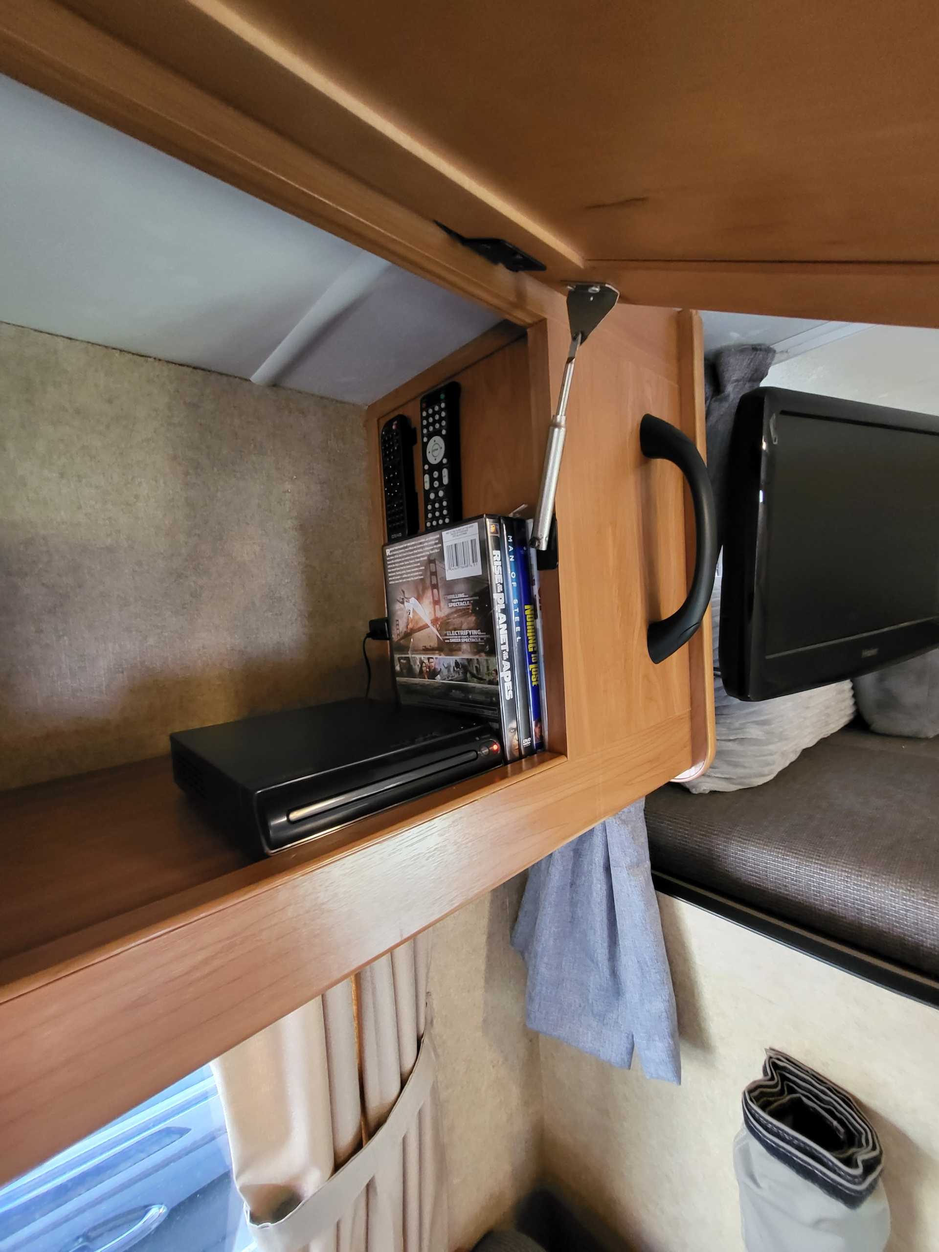 This RV rental features a cozy entertainment nook with a DVD player, movies, remote controls, and a wall-mounted TV.. Thor Majestic 2014