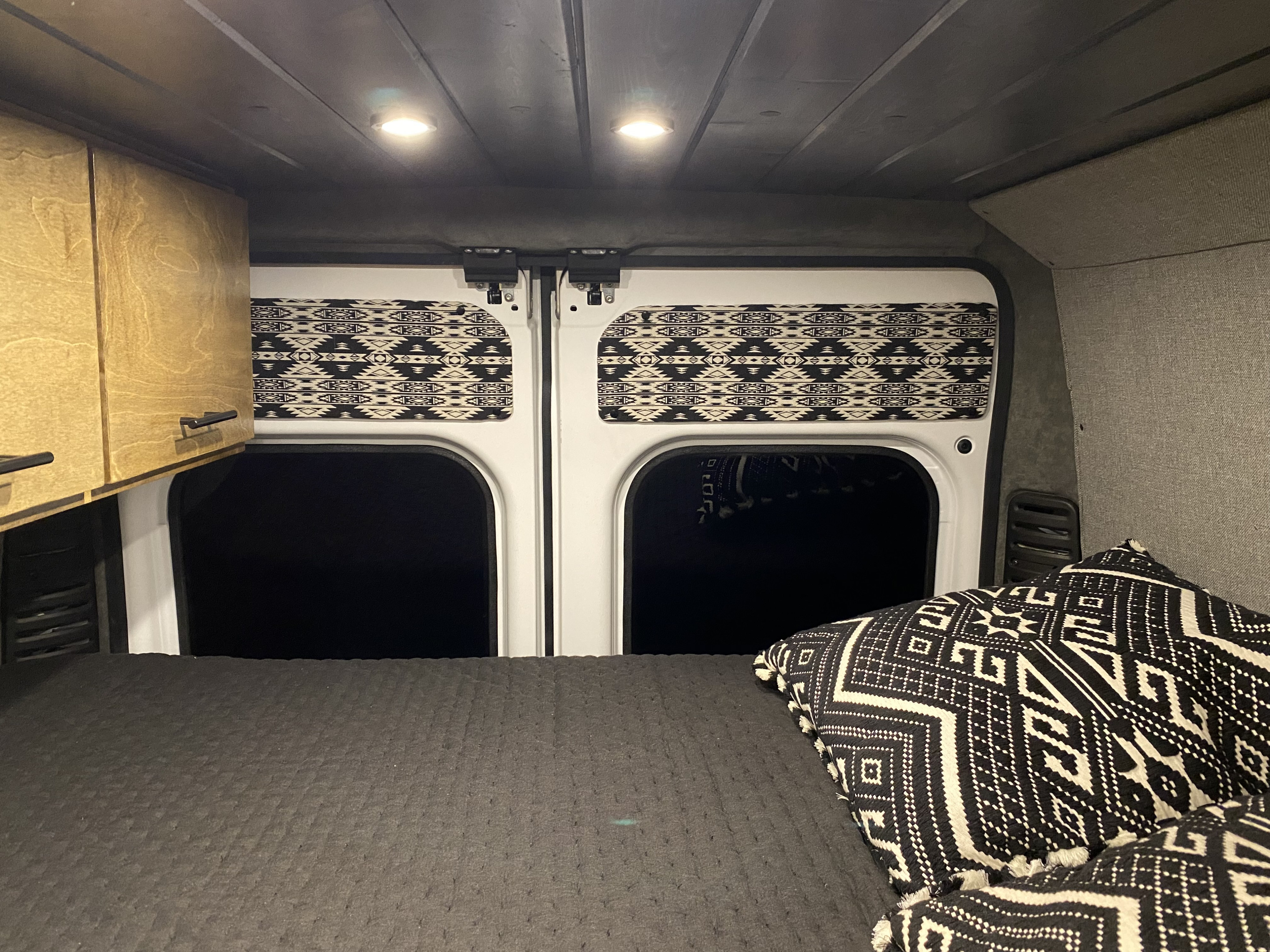 Enjoy comfort in this RV rental: custom bed, patterned pillows, wood cabinets, & privacy window covers.. Other Other 2019