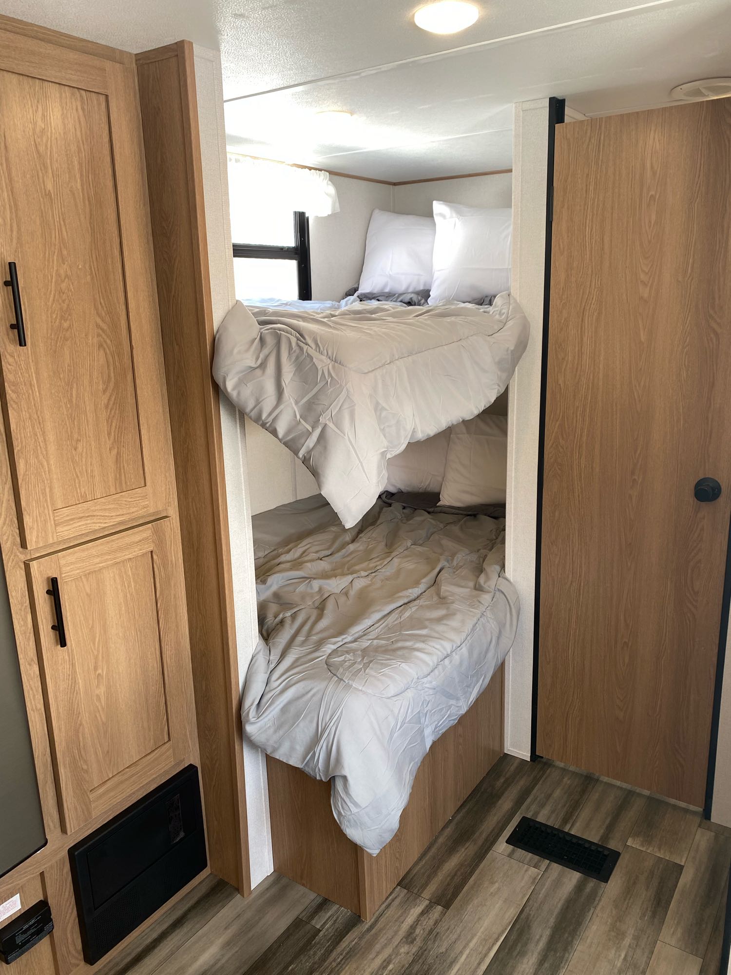RV rental interior showcasing comfortable bunk beds, light bedding, and warm wood cabinetry, ideal for family trips.. Prime Time Avenger 26DBSLE 2022