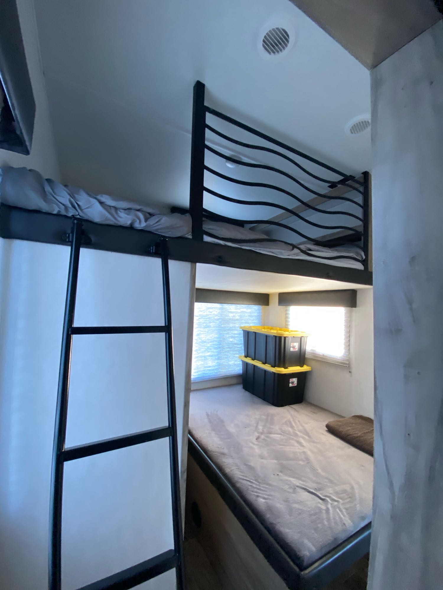 RV rental interior showcasing bunk beds, a ladder, lower bed, and stacked storage bins, offering a practical sleeping space.. Forest River Arctic Wolf 3770 Suite 2021