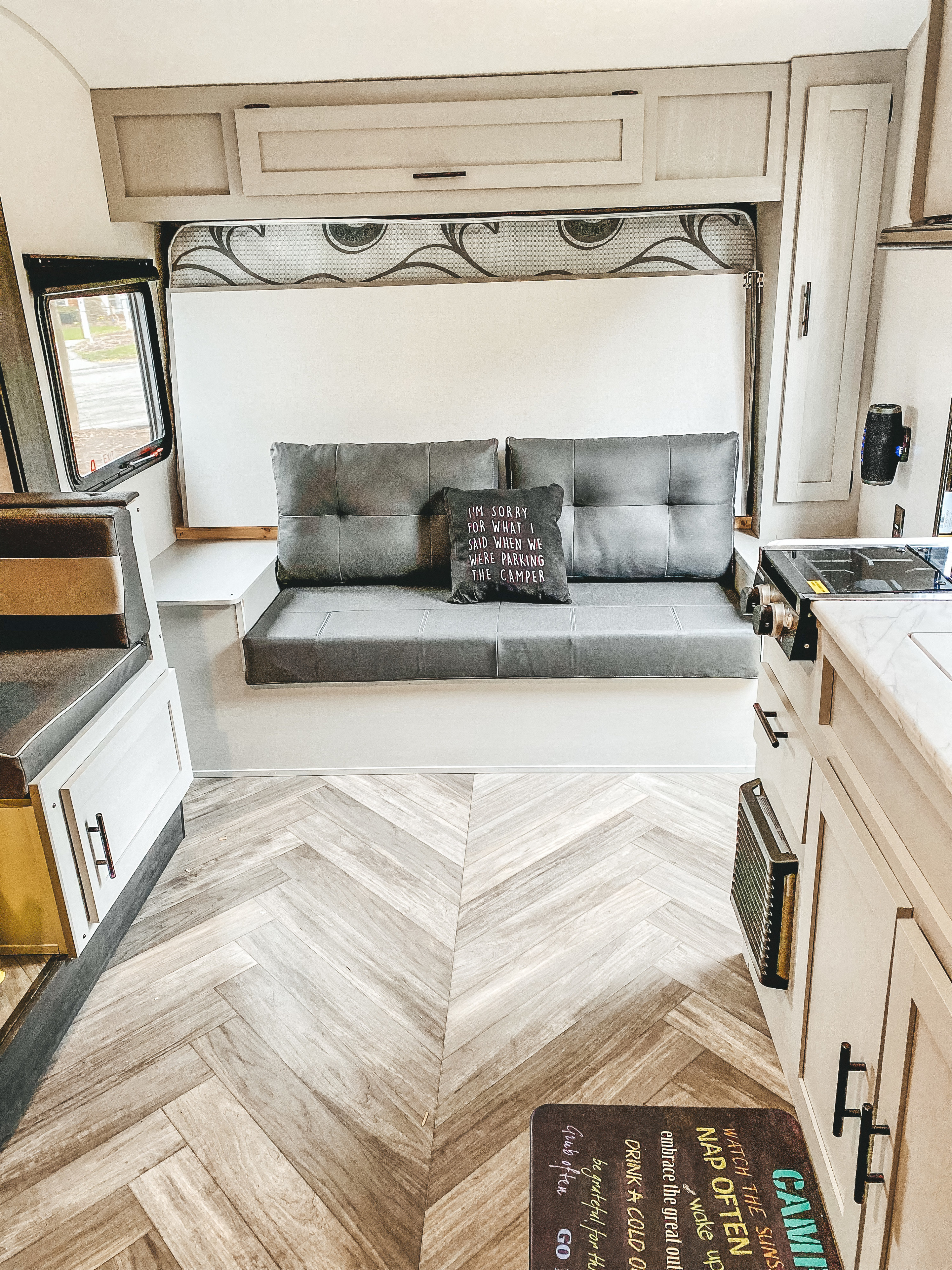 Cozy rv rental living space with a grey sofa, functional kitchenette, and clever storage solutions.. Forest River Other 2022
