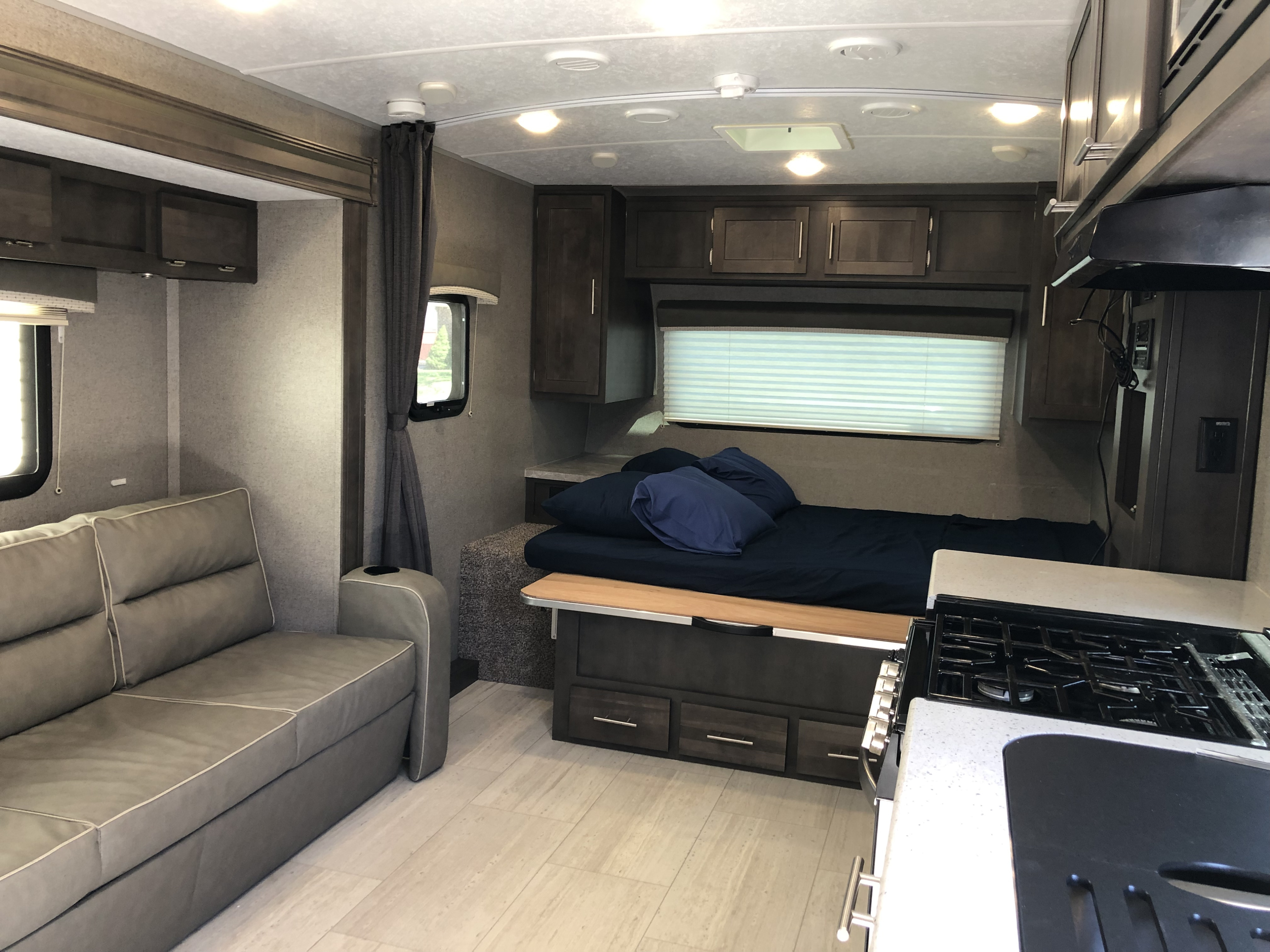 Inside an RV rental: a compact yet complete living space with sofa, bed, and kitchen amenities.. Forest River Rockwood Mini Lite 2020