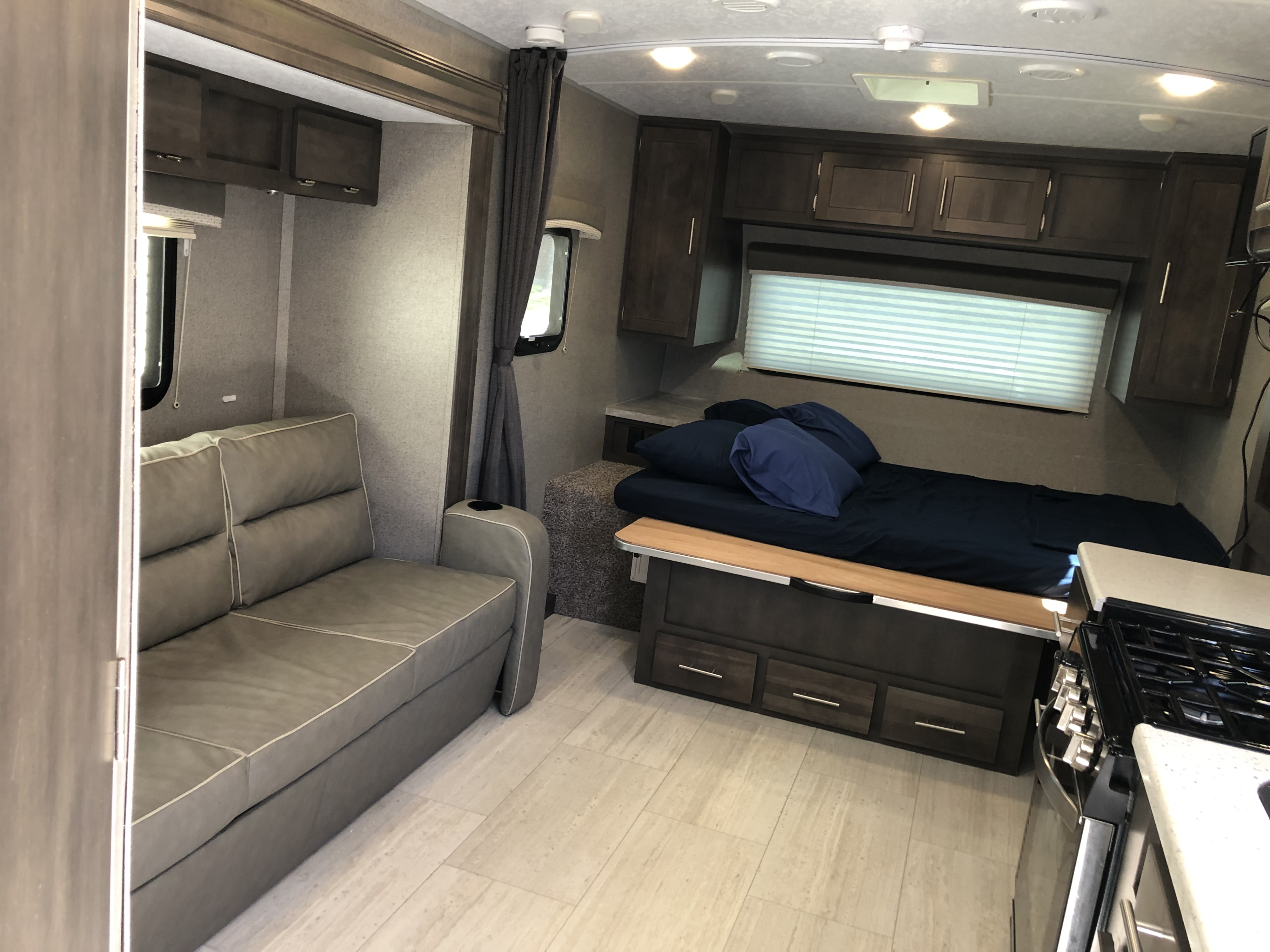 Spacious interior of an RV rental featuring a sofa, bed, and compact kitchen area for comfortable living.. Forest River Rockwood Mini Lite 2020