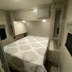 Cozy RV rental bedroom with a queen bed, overhead cabinets, and side storage. Ideal for comfortable travel.. Coachmen Catalina 2022