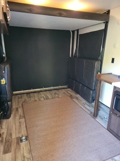 RV rental interior: A versatile toy hauler garage area with lift bed, wood flooring, and rug. Ready for adventure.. Jayco Octane 2018