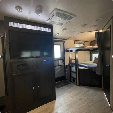 RV rental interior showing bunk beds, a TV, and an entrance, creating a comfortable living space for travelers.. Cruiser Rv Corp Shadow Cruiser 2018