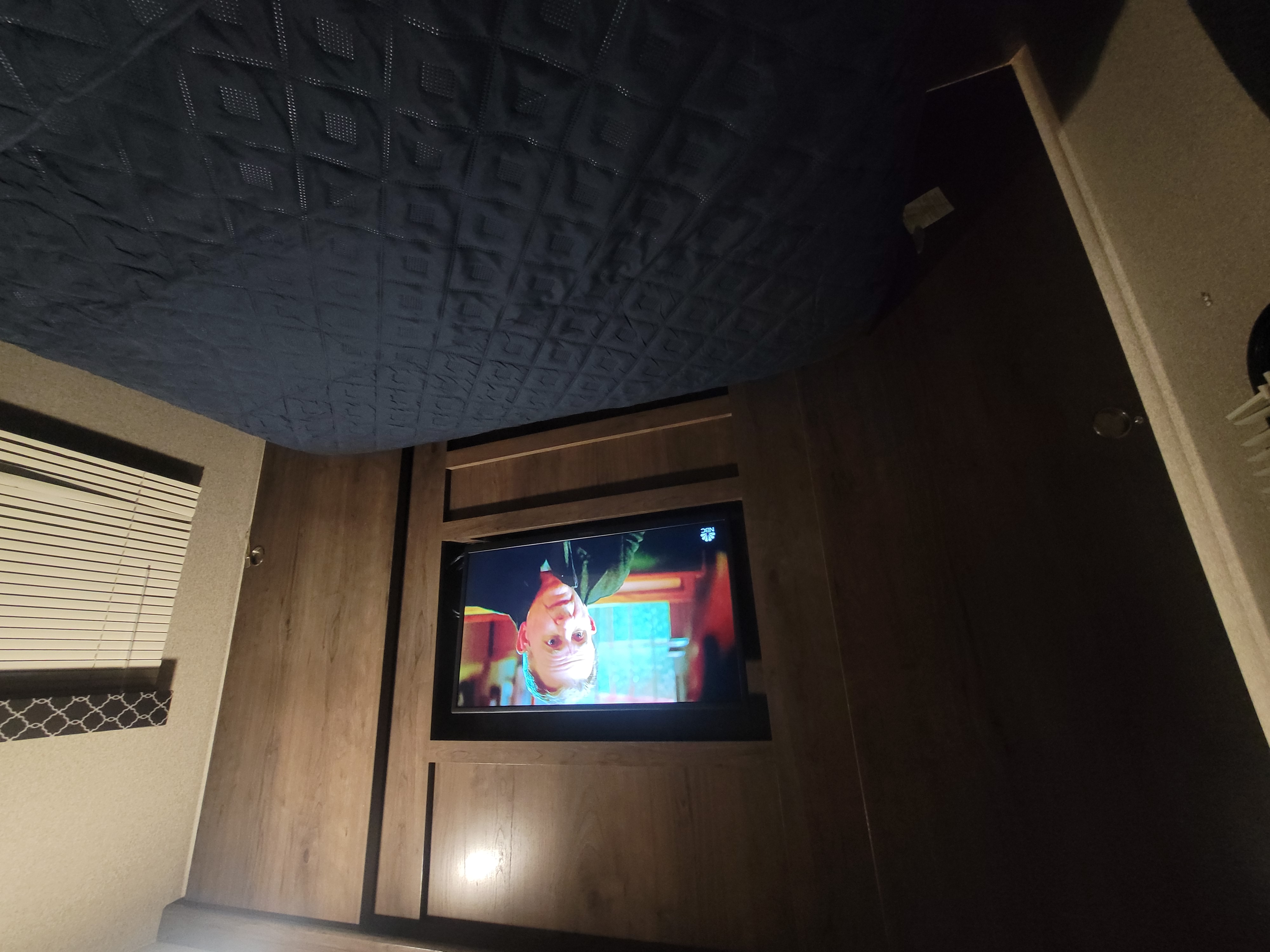 RV rental bedroom with TV & bed, featuring cozy wooden interior and blinds.. Keystone RV Passport Grand Touring 2019
