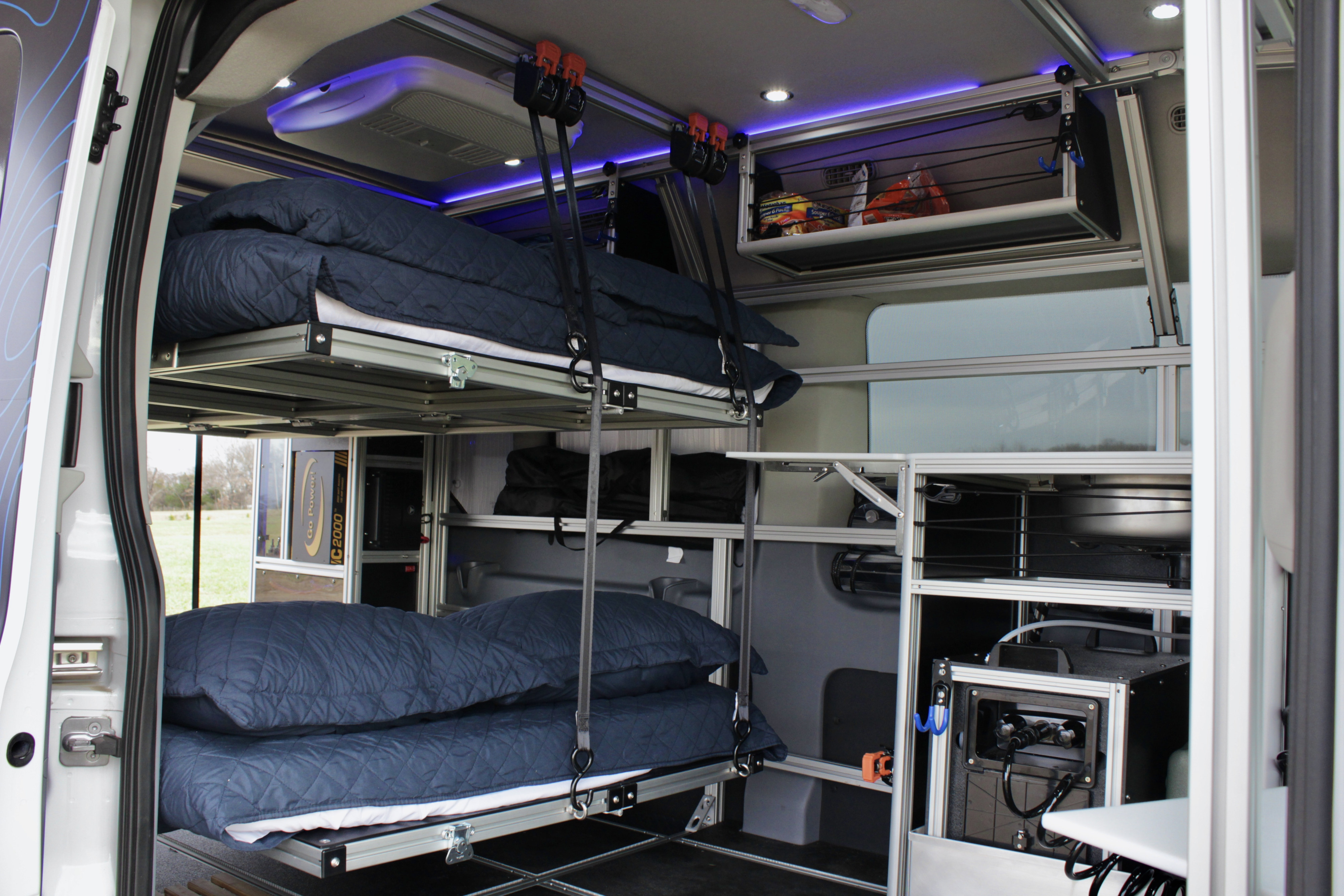Modular RV rental interior featuring suspended bunk beds, smart storage, and integrated power for travel comfort.. vandoit DO 2018