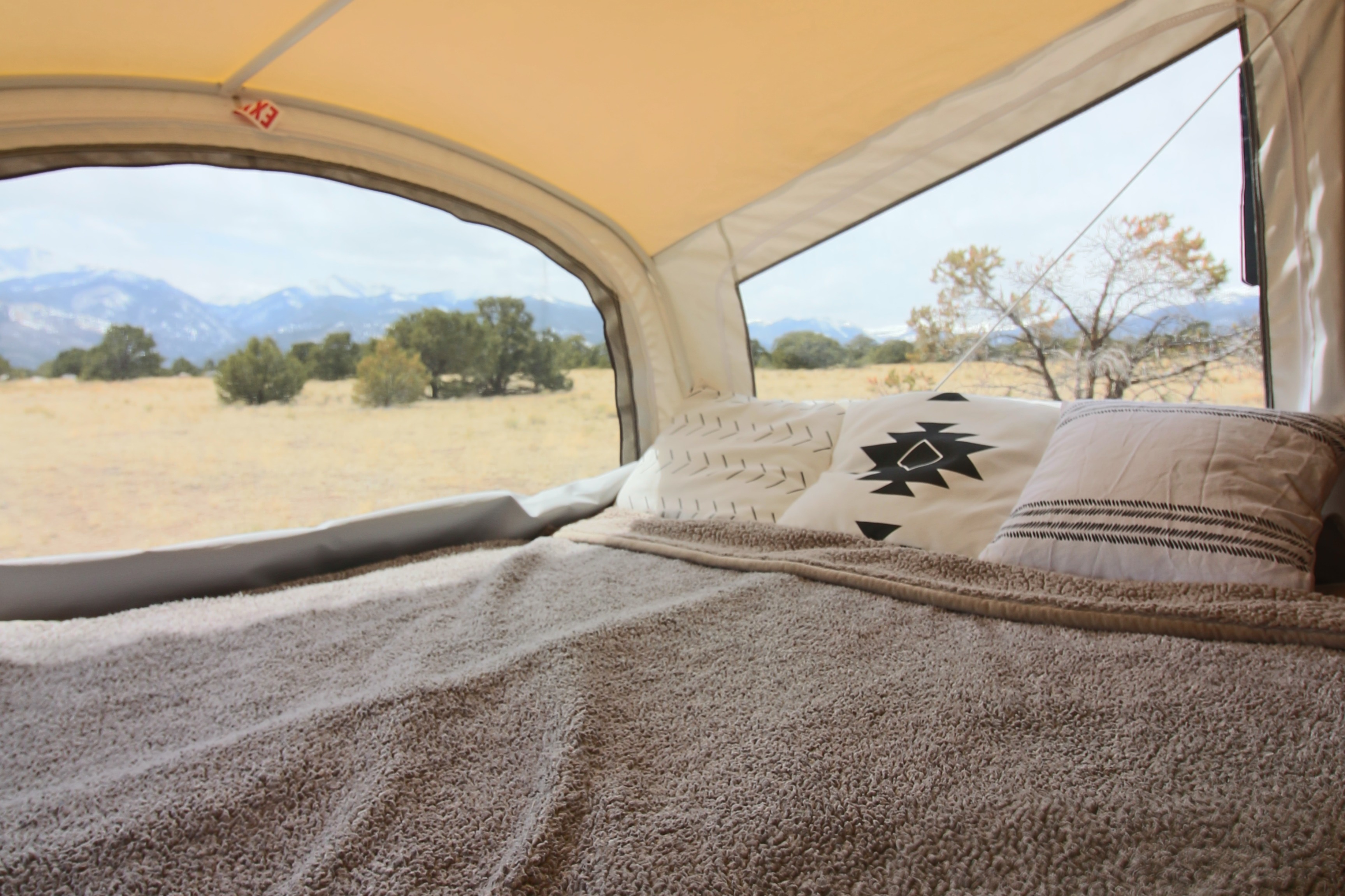 Comfortable RV rental bed with pillows and blanket offers stunning mountain views from inside the camper.. Starcraft Launch 2016