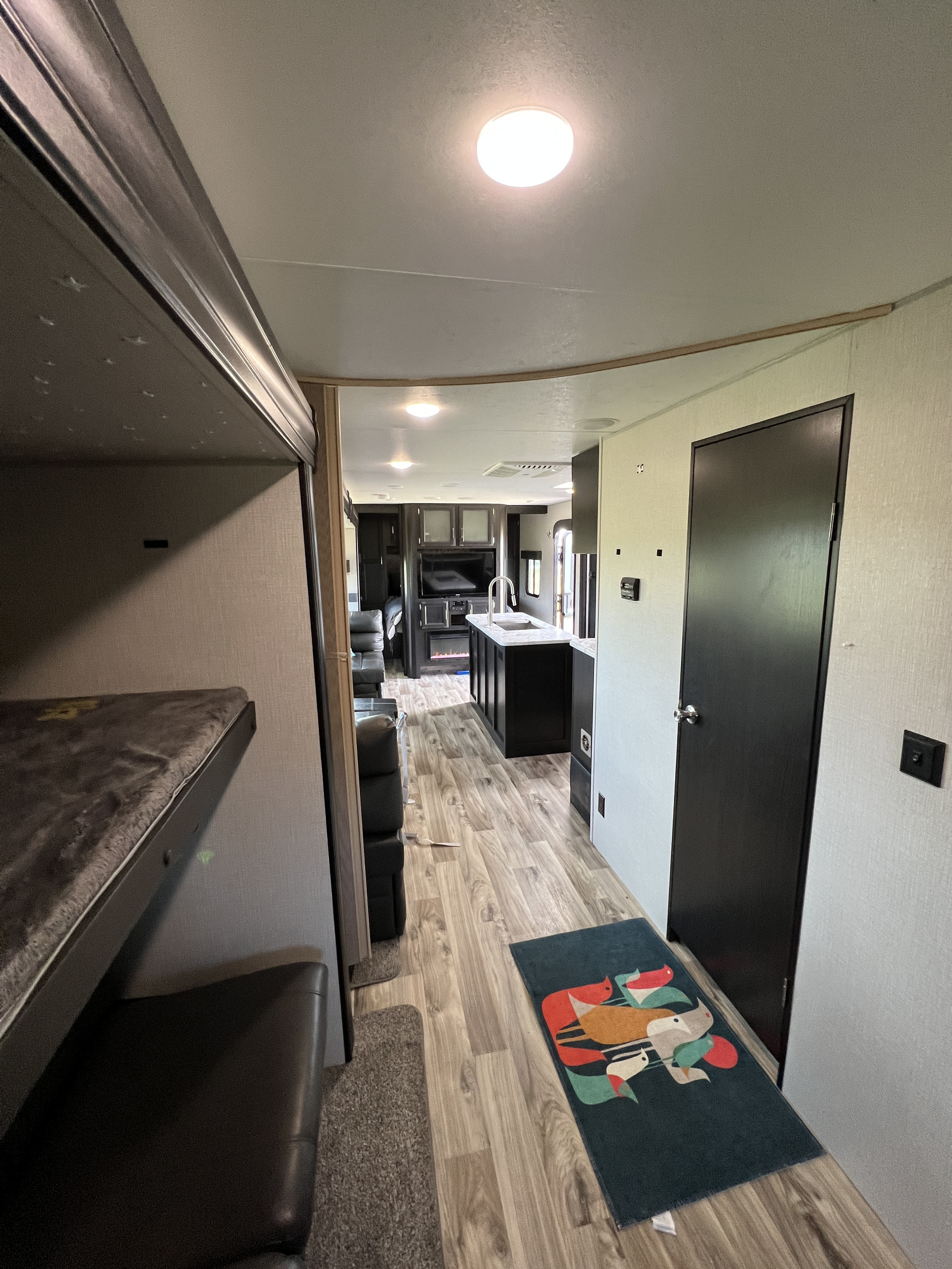 RV rental interior with a bunk bed area, hallway, modern kitchen island, and living space.. Venture Stratus 2020