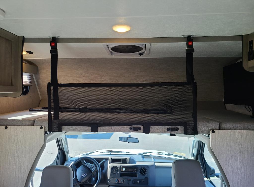 RV rental: The over-cab bunk with safety net, ceiling lights, fan, and front dashboard view.. Forest River Coachmen Cross Trail XL 2022