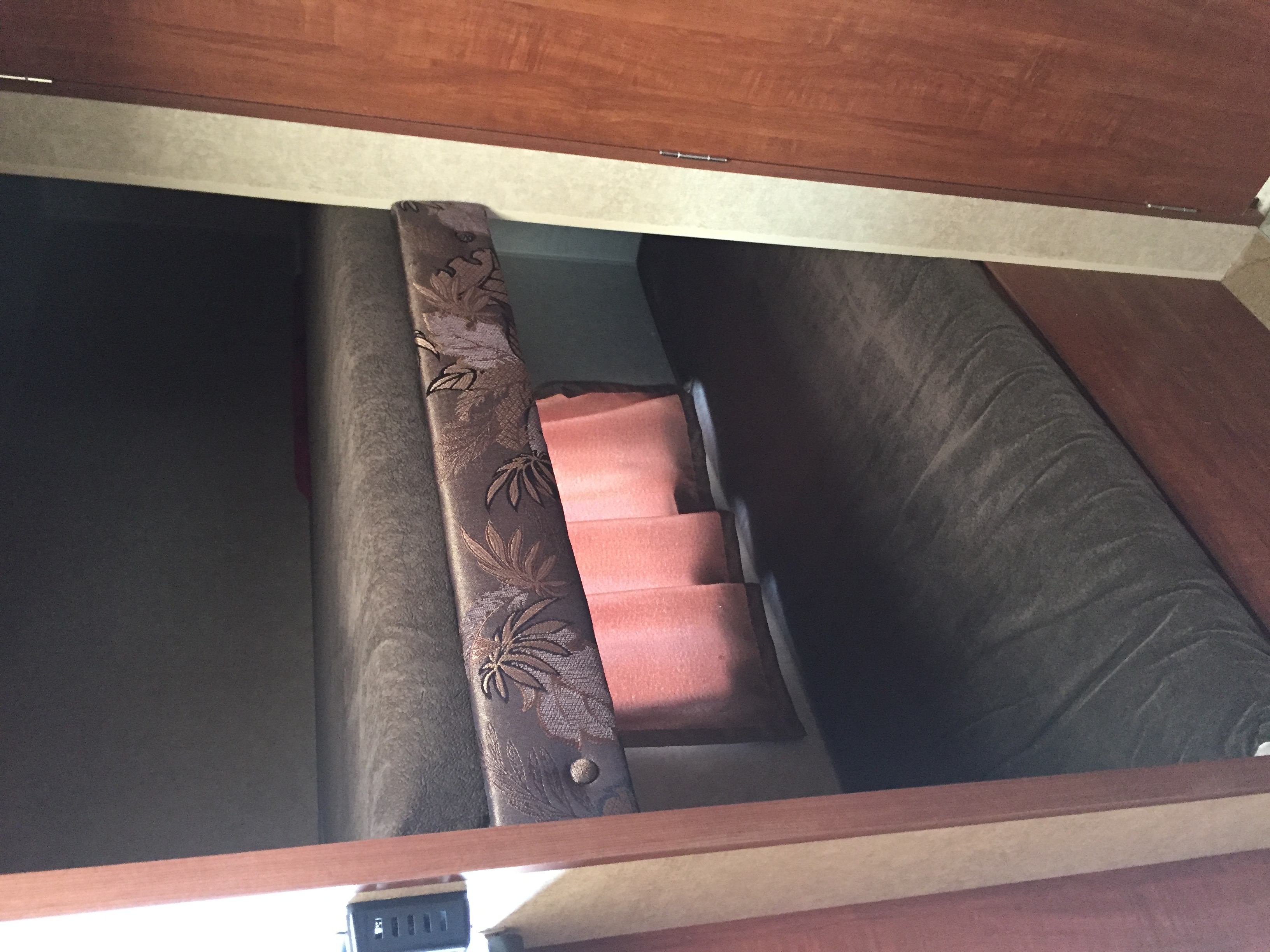 RV rental interior: narrow bunk beds with patterned bolster & soft pink steps. Cozy sleeping space.. Jayco Bambi 2014