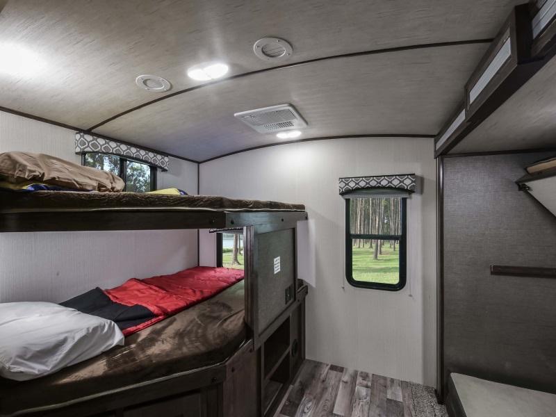Cozy RV rental bunk beds, fully made with bedding, offer comfortable sleeping & a view of nature.. Radiance Big Bear 2020