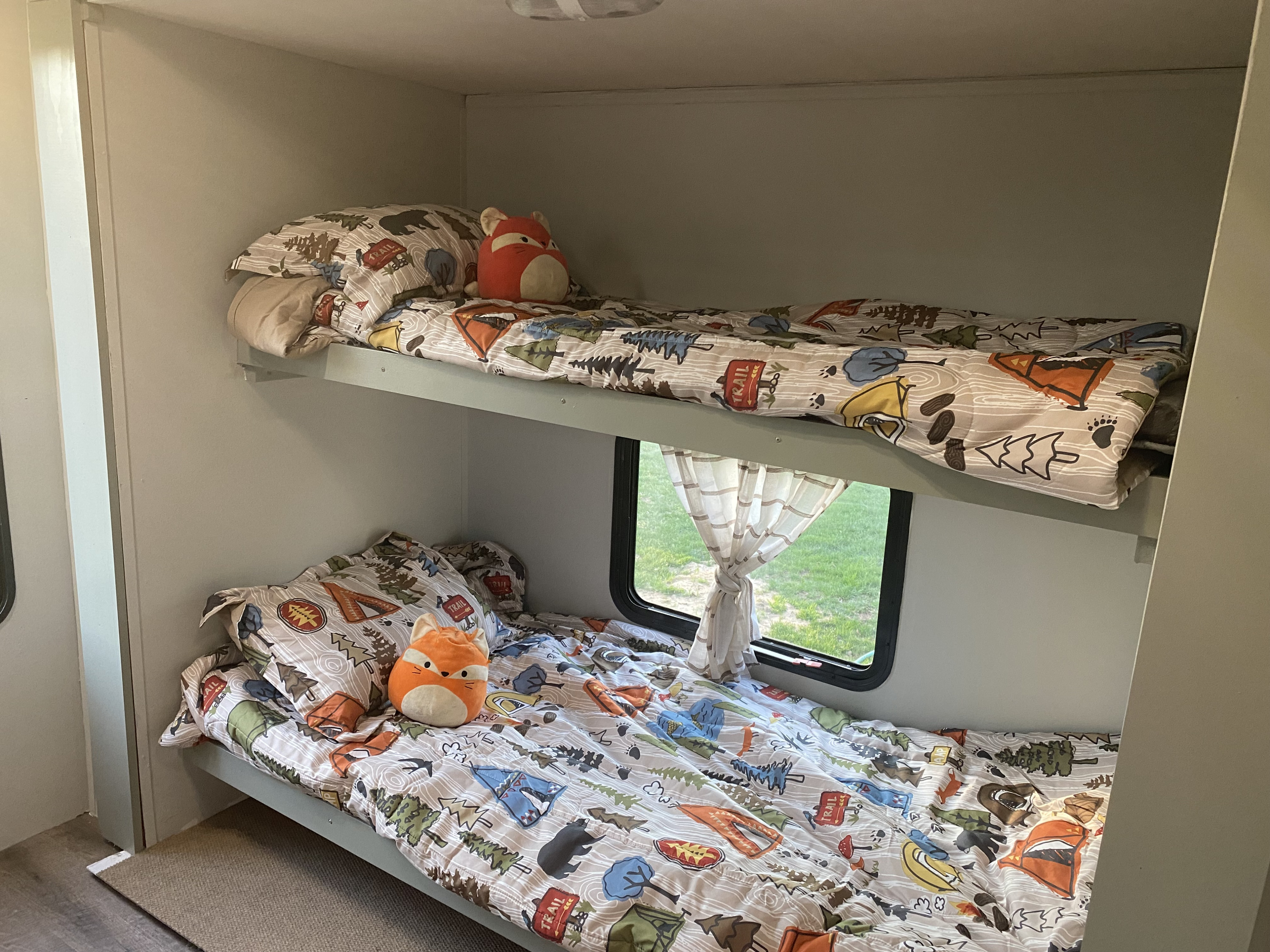 Cozy RV bunk beds with fun camping-themed bedding and stuffed foxes. Ideal for your family's next rv rental adventure.. Gulf Stream Conquest 2015