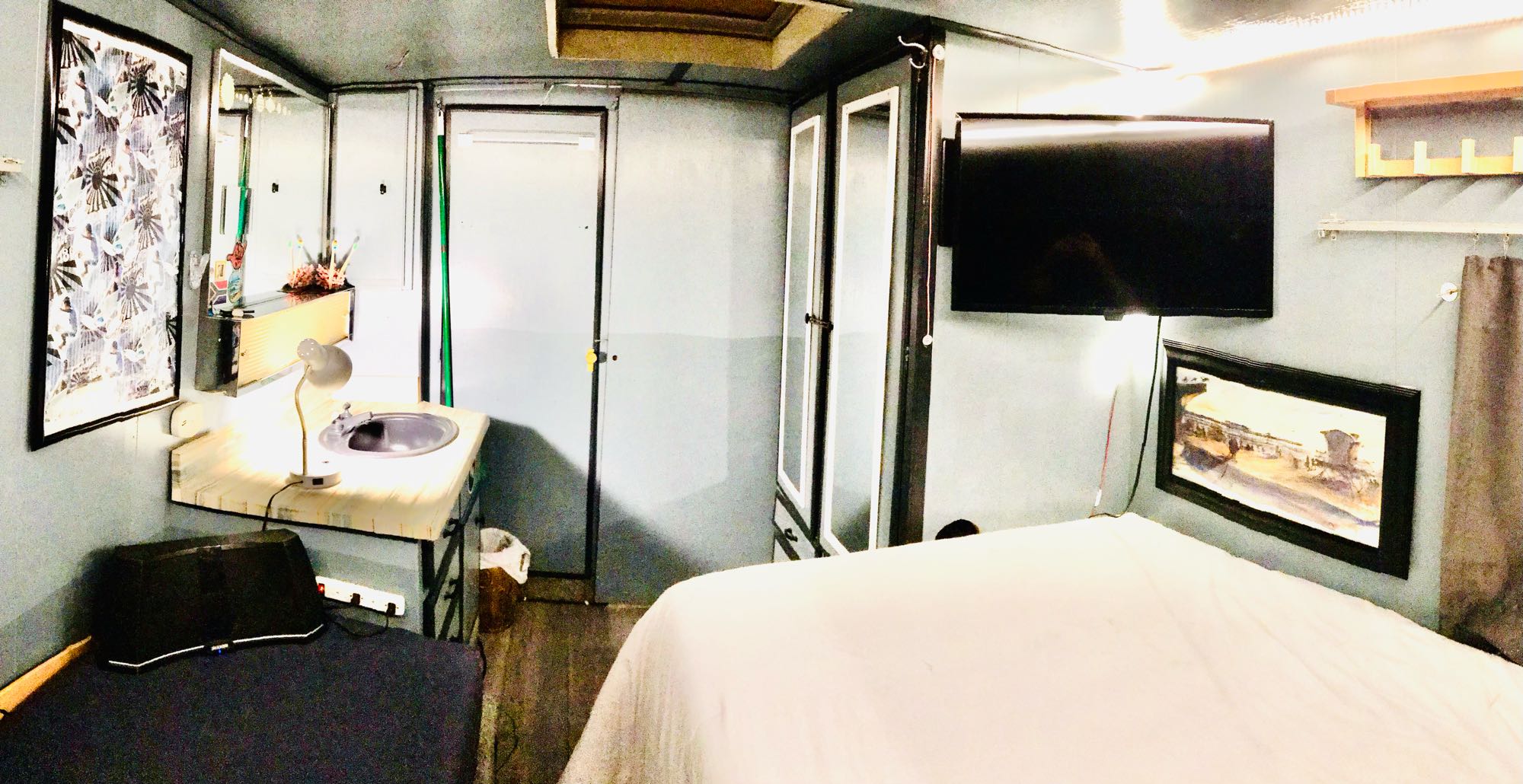 • Fold out TV and DVD player • Bluetooth speakers • Bedroom sink • Door to bathroom • Room divider door closed • Hanging closet on right • Local art . Dodge Commander 1974