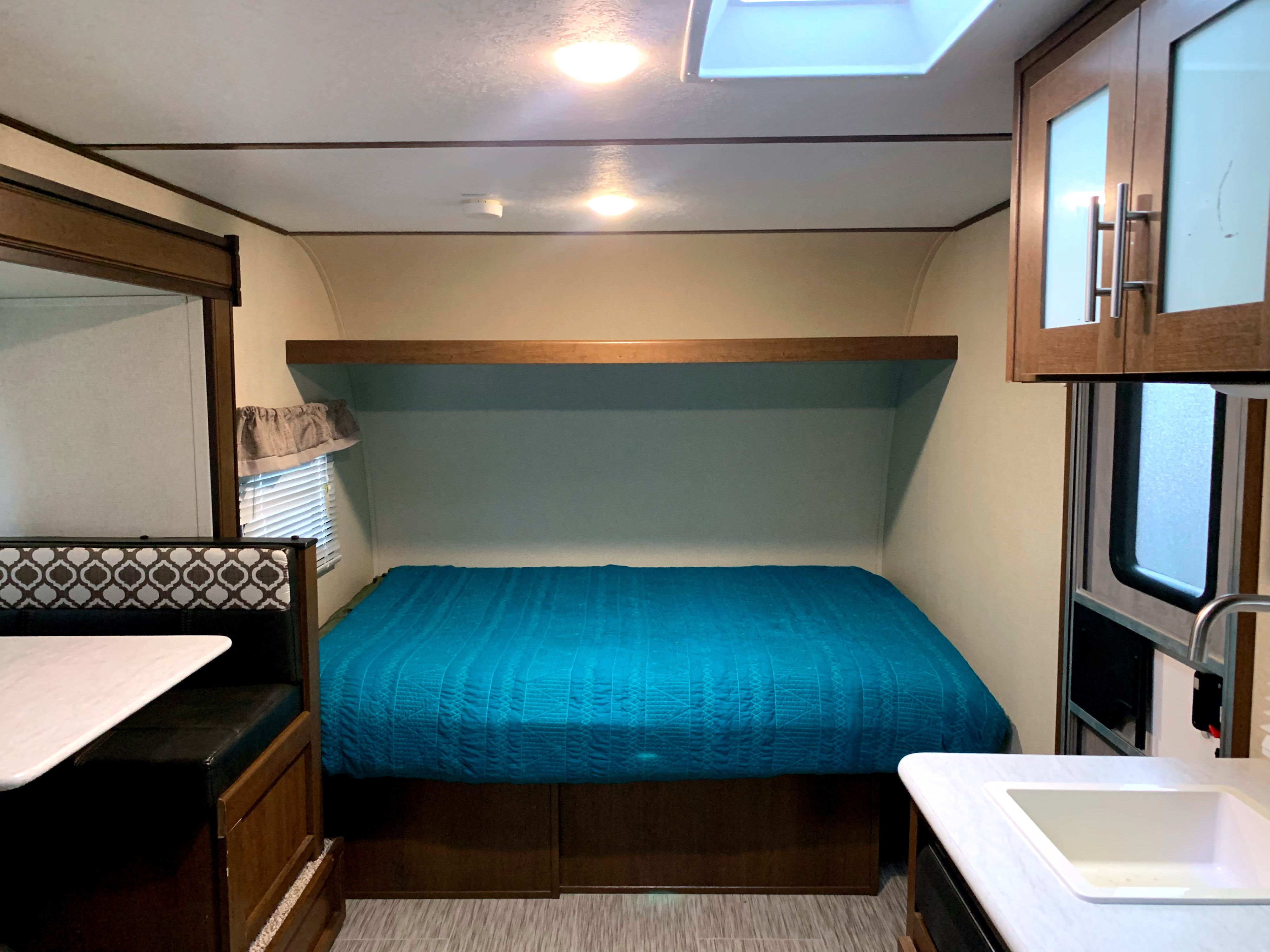 Queen size bed in the living space with storage shelf above.. PTX PTX Trailer 2020