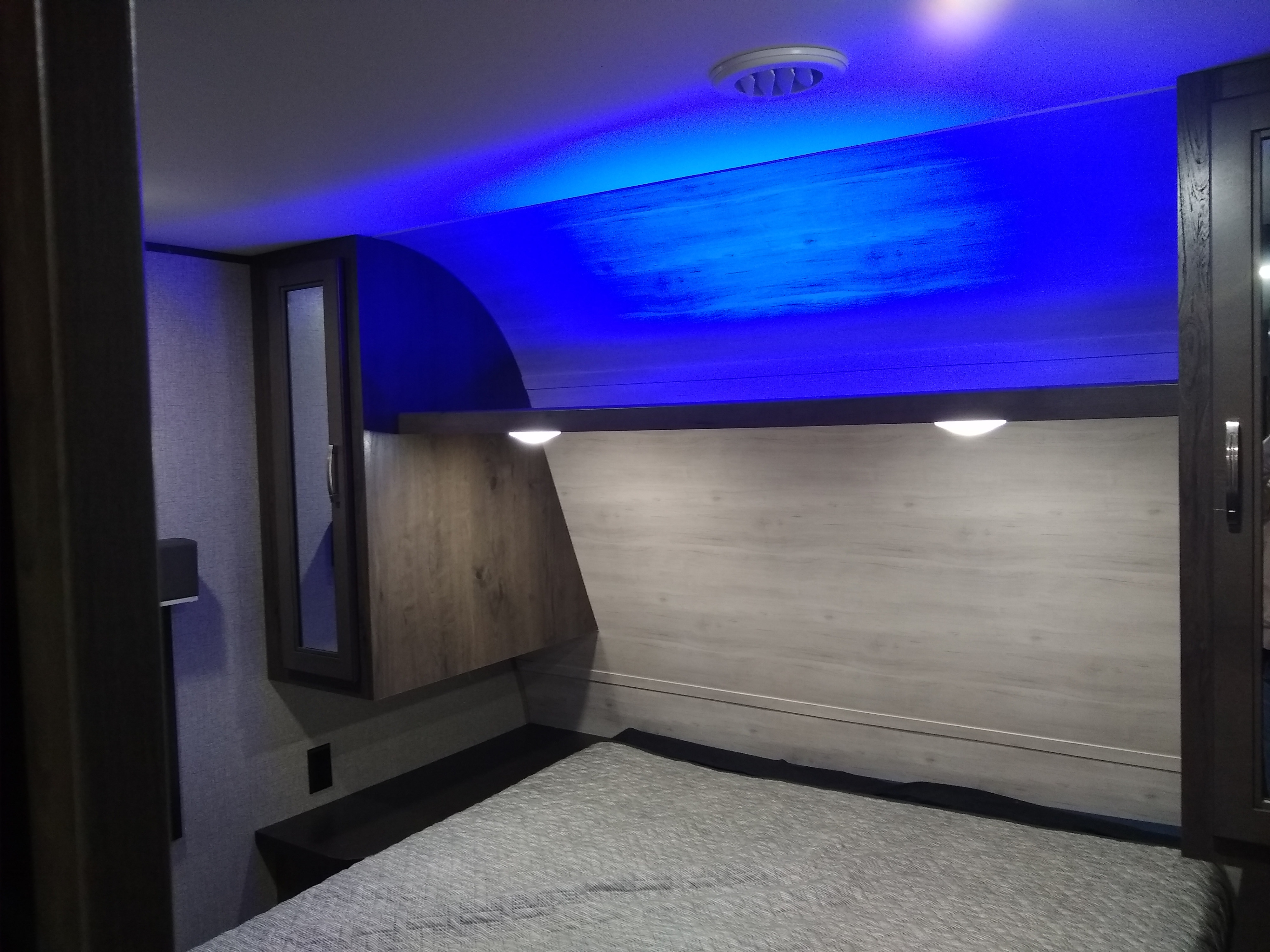 Cozy RV rental bedroom featuring modern blue LED lighting, comfy bed, and built-in storage.. Jayco Jay Flight SLX 2021