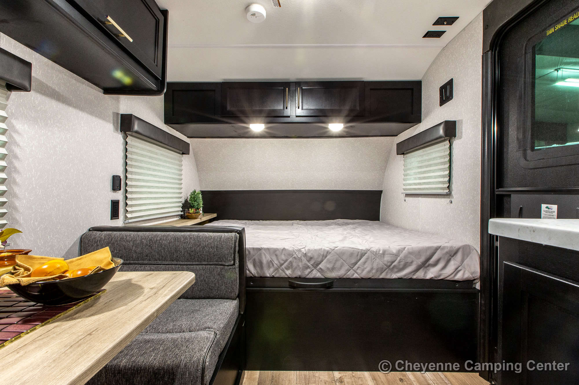 RV rental interior: cozy bedroom with a bed, seating area, and overhead cabinets. A compact, comfortable space.. Forest River Cherokee Wolf Pup 2022