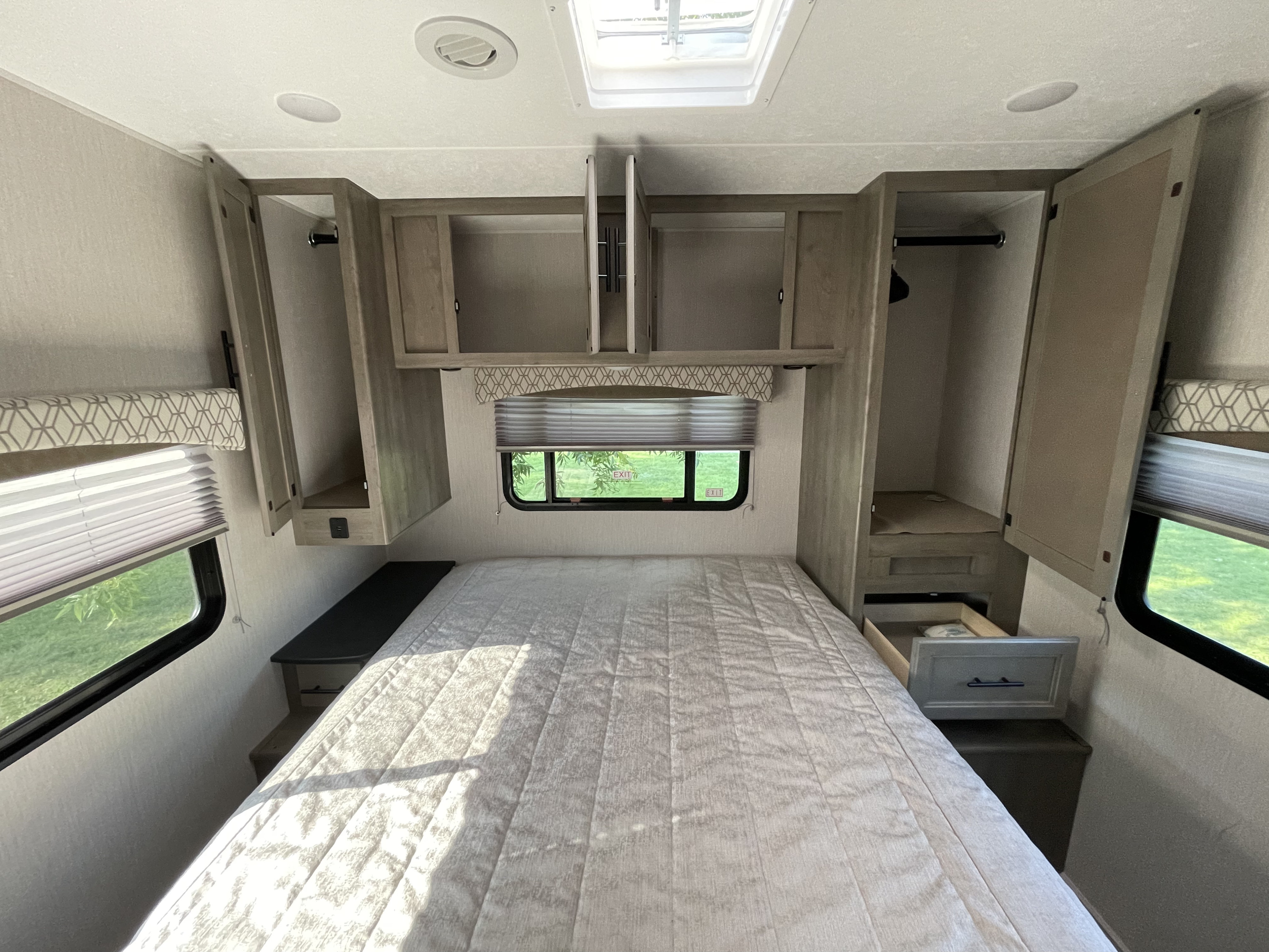 Cozy RV rental bedroom with overhead storage, closets, and ample natural light from exterior windows.. Forest River Coachmen Freelander 2021