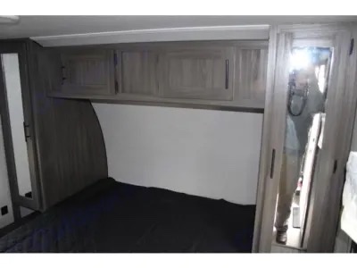 This RV rental bedroom features overhead storage, a bed, and mirrored wardrobes for compact living.. Other Other 2021