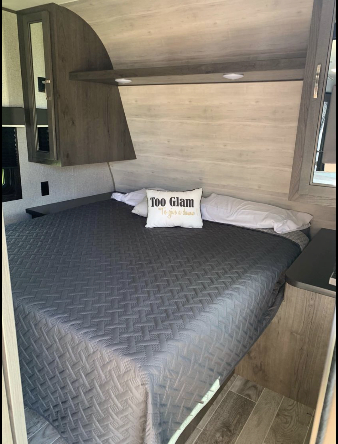 Comfortable RV rental bedroom featuring a gray quilted bed, white pillows, and "Too Glam" pillow, perfect for travel.. Jayco Jay Flight SLX 2021
