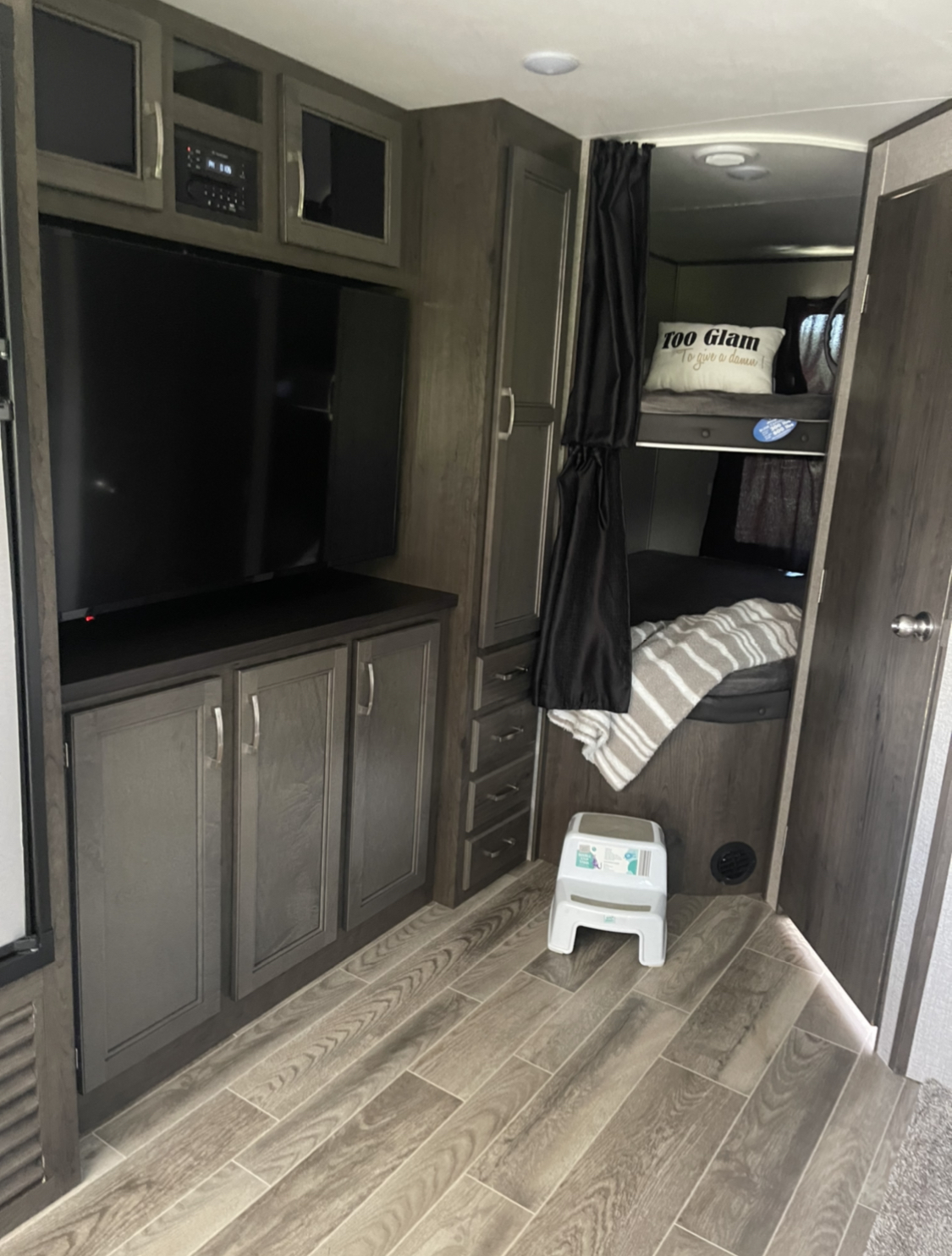 RV rental interior: modern design with TV, bunk beds, privacy curtains, and smart storage. Ideal for family travel.. Jayco Jay Flight SLX 2021