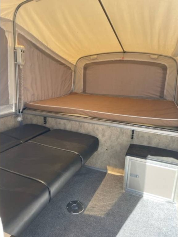 Spacious RV rental interior with a comfy bed, foldable seating, and a cooler. Ideal for adventurers.. Livin Lite Quicksilver 6.0 2014