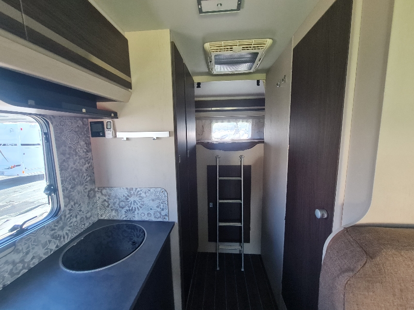 Explore this rv rental: compact kitchenette, bunk bed with ladder, and cozy living space.. Rimor Seal 5 2022