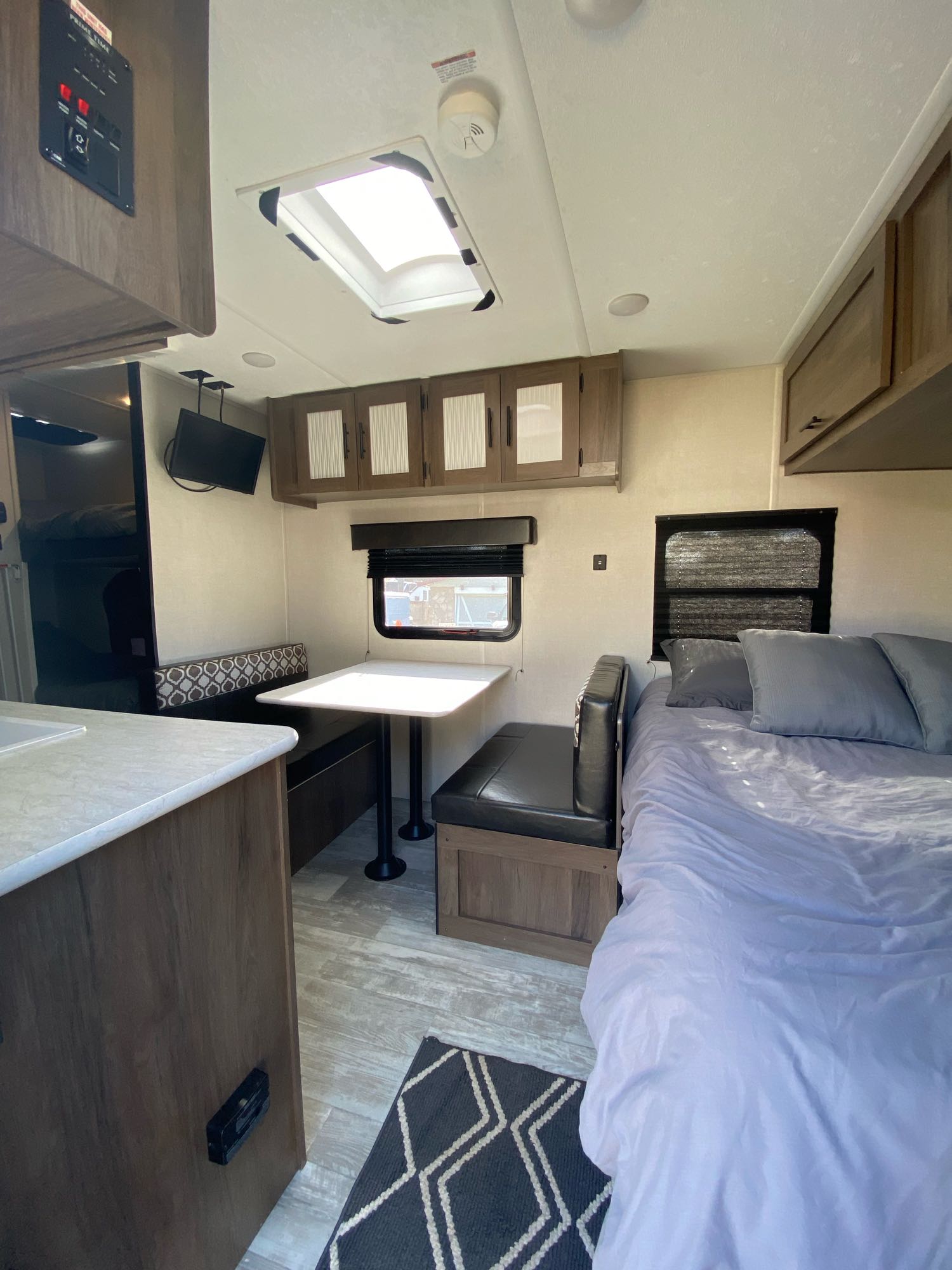 Modern RV rental interior with a compact kitchen, dinette, comfy bed, and ample storage.. Prime Time Avenger 2021