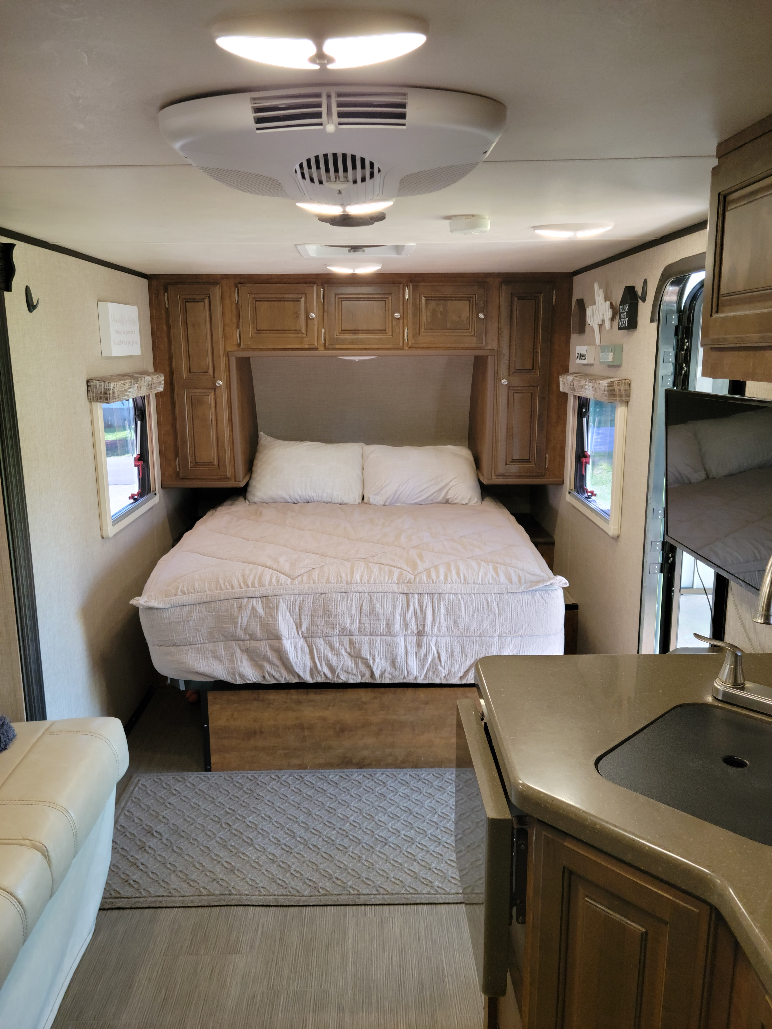 Spacious RV rental interior featuring a queen bed, abundant storage, and a small kitchen area with a sink.. Other Other 2018