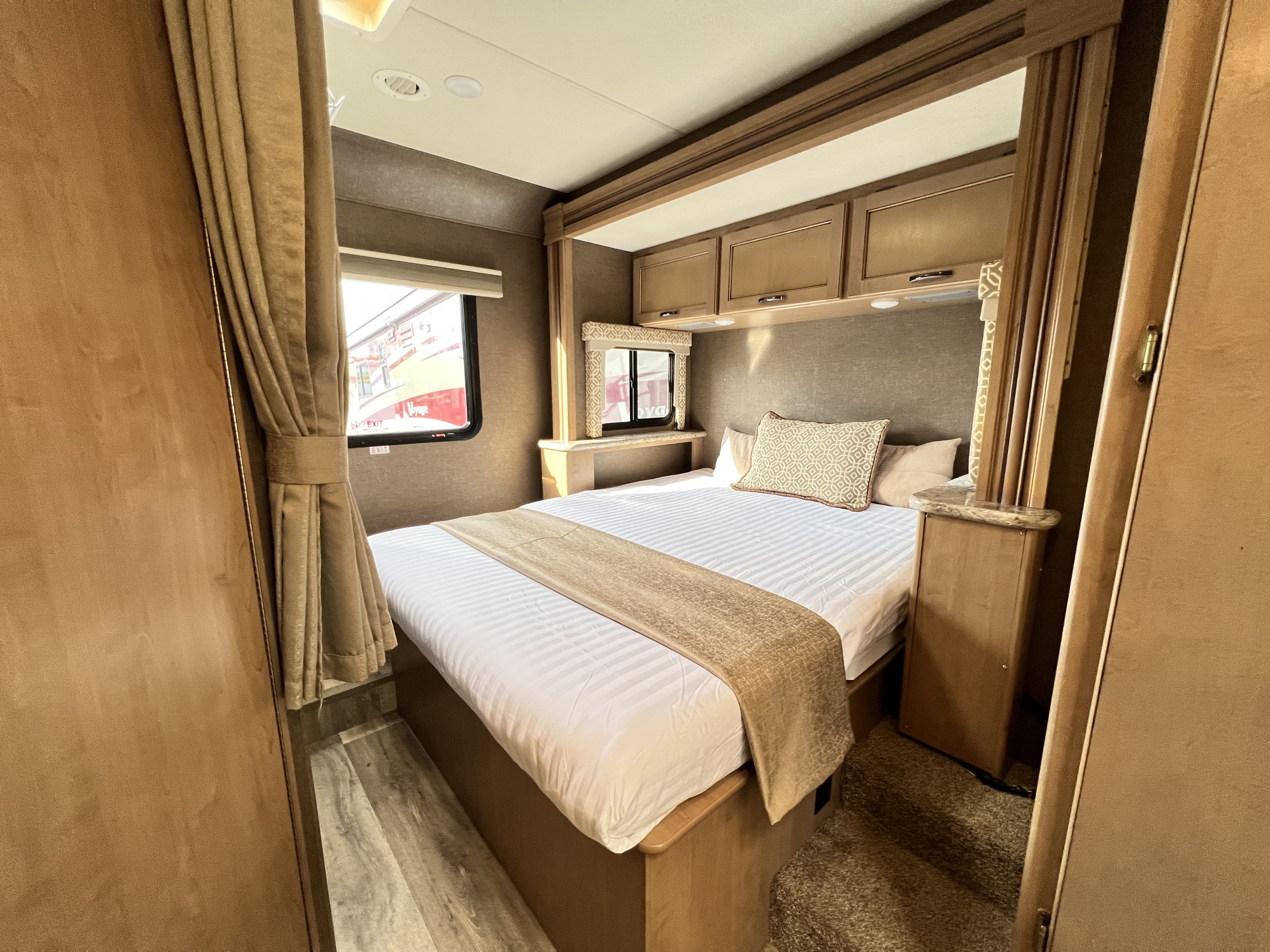 Modern RV rental bedroom with a cozy bed, overhead storage, and window. Perfect for comfortable travels.. Thor Freedom Elite 2018