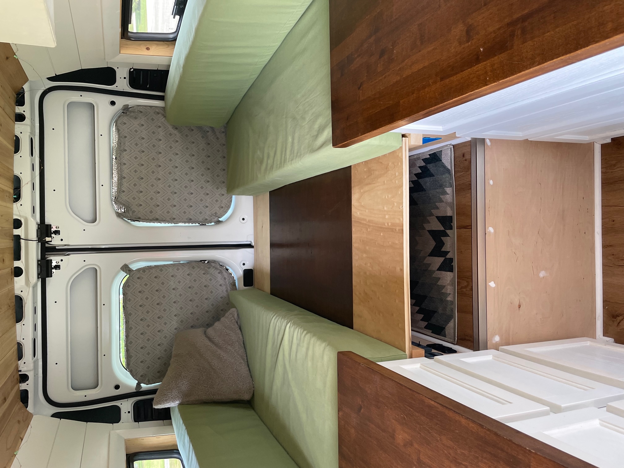 Inside an RV rental conversion: light green seating, wood walls, and new white cabinet panels.. Ram Promaster 2500 High Roof 2500 159 WB 2019