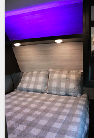 RV rental bedroom: cozy space with gray plaid bedding, wood headboard, and unique purple accent lighting.. Jayco JayFlight 267BHSW 2022