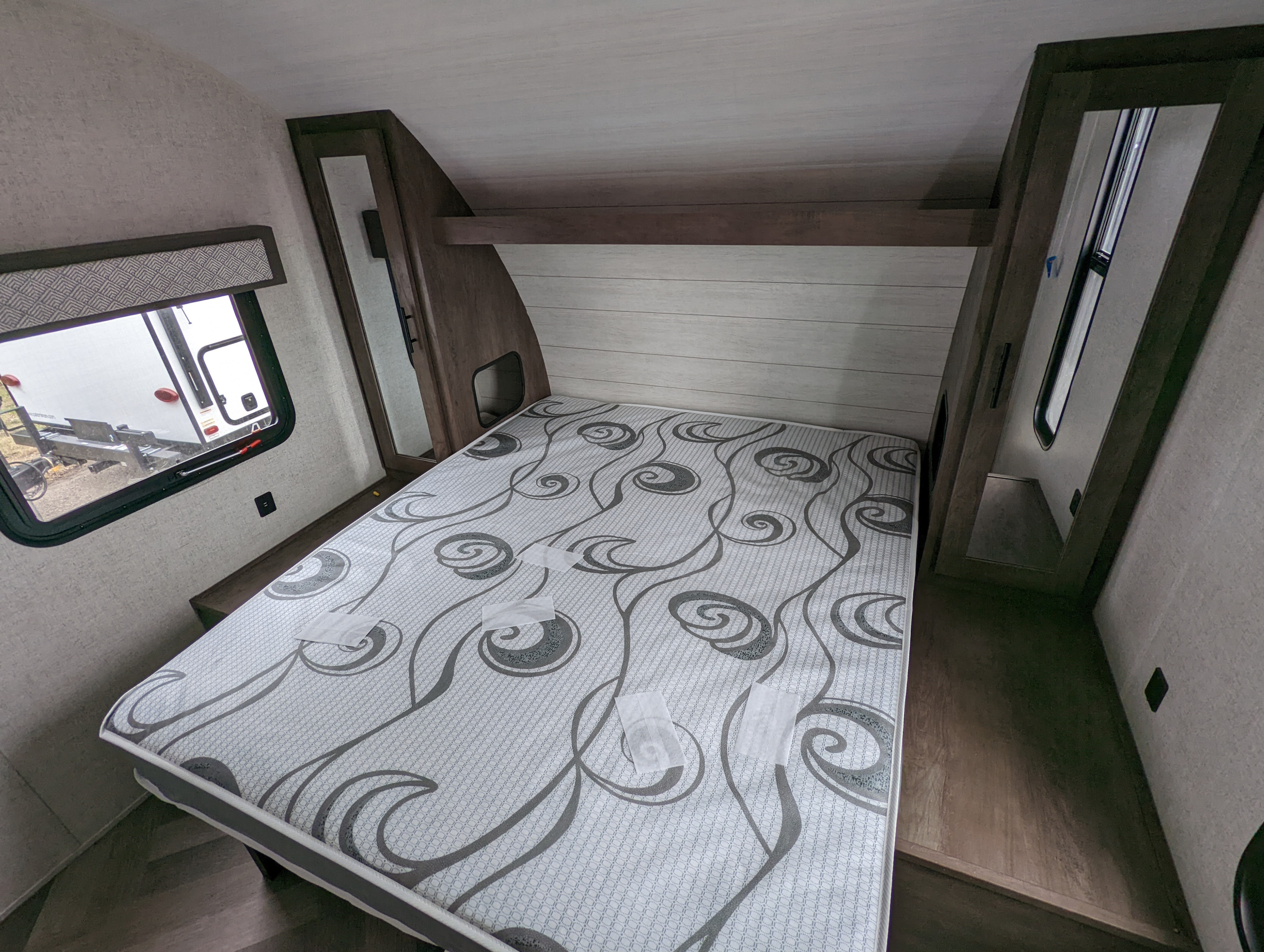 Explore this modern RV rental bedroom featuring a patterned mattress, window, and integrated storage, perfect for your next trip.. Forest River Salem Cruise Lite 2020