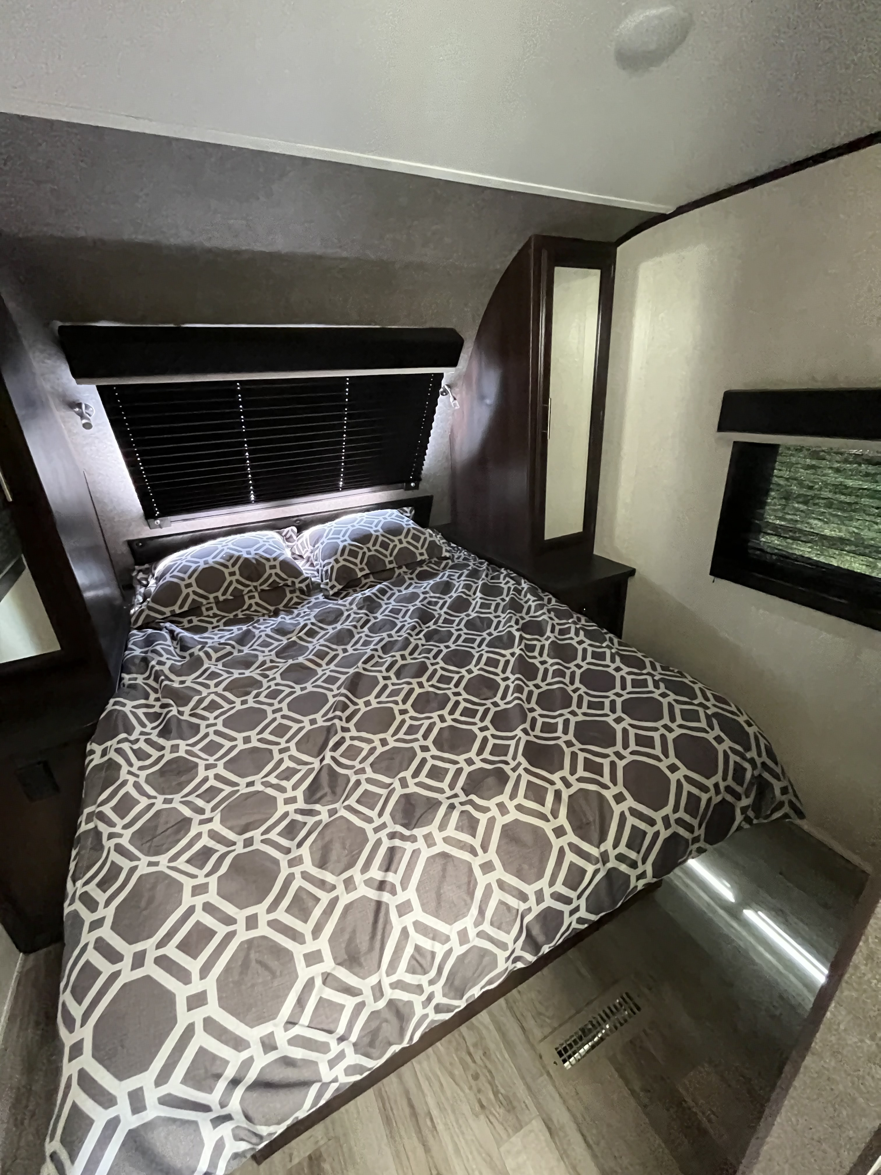 RV rental bedroom: comfortable bed with geometric bedding, reading light, and mirrored storage.. Jayco White Hawk 2019